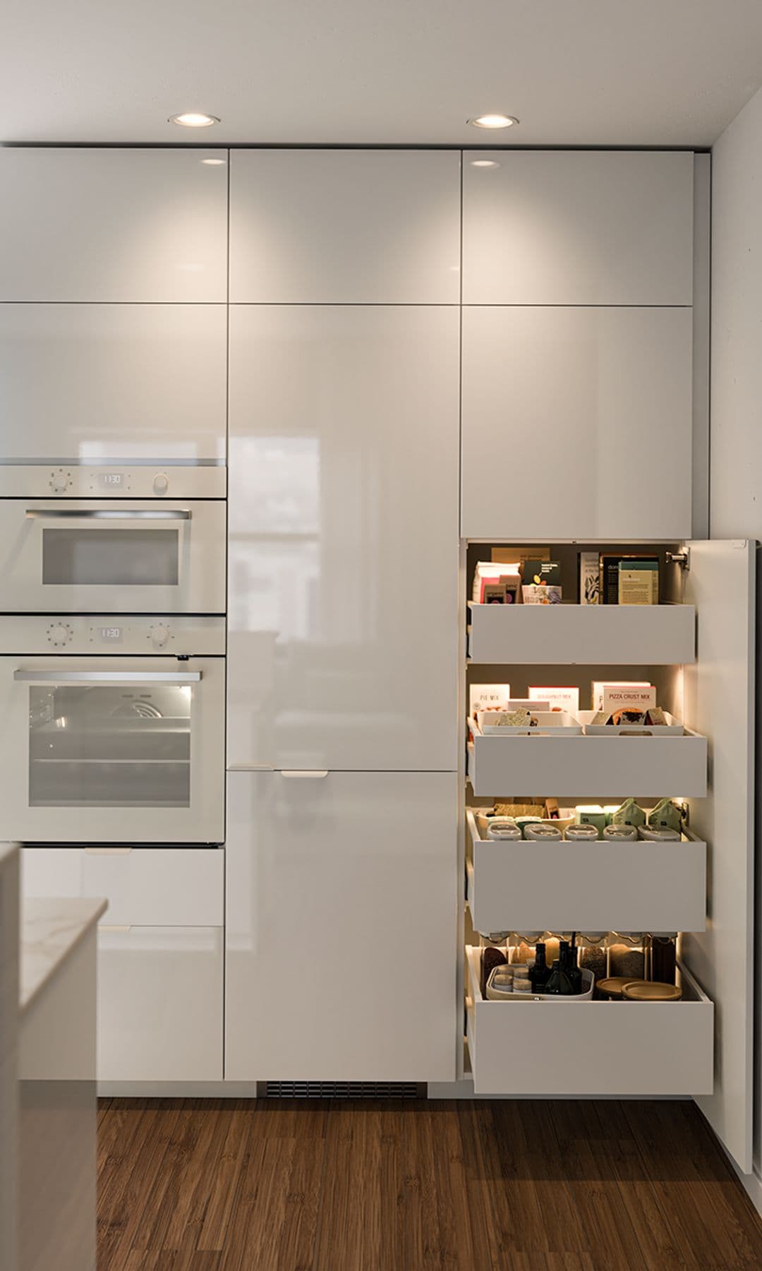 Cocina IKEA blanca, con frigorífico integrado, despensa, horno y microondas en columna de color blanco.