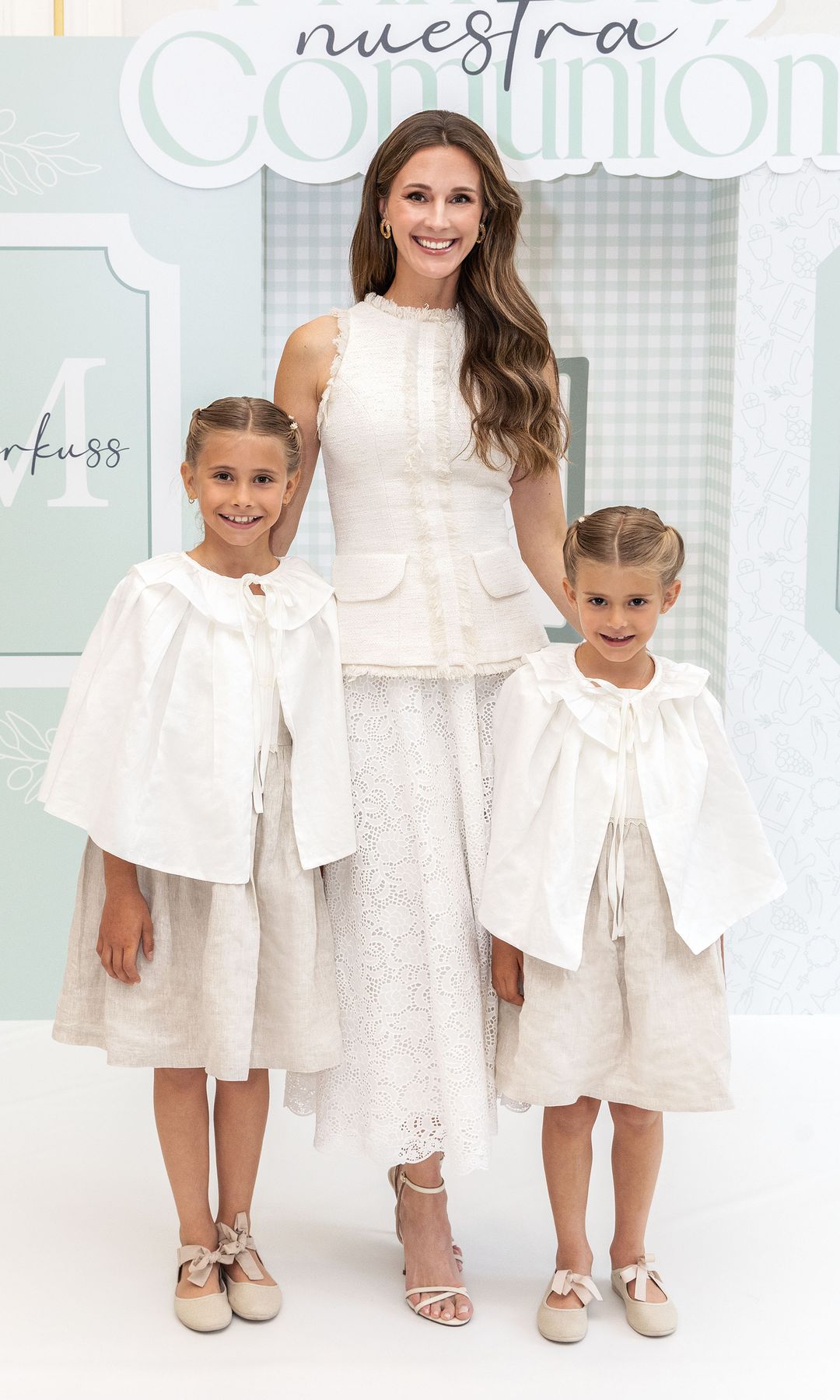 Astrid Klisans junto a sus hijas en la comunión de su pequeño