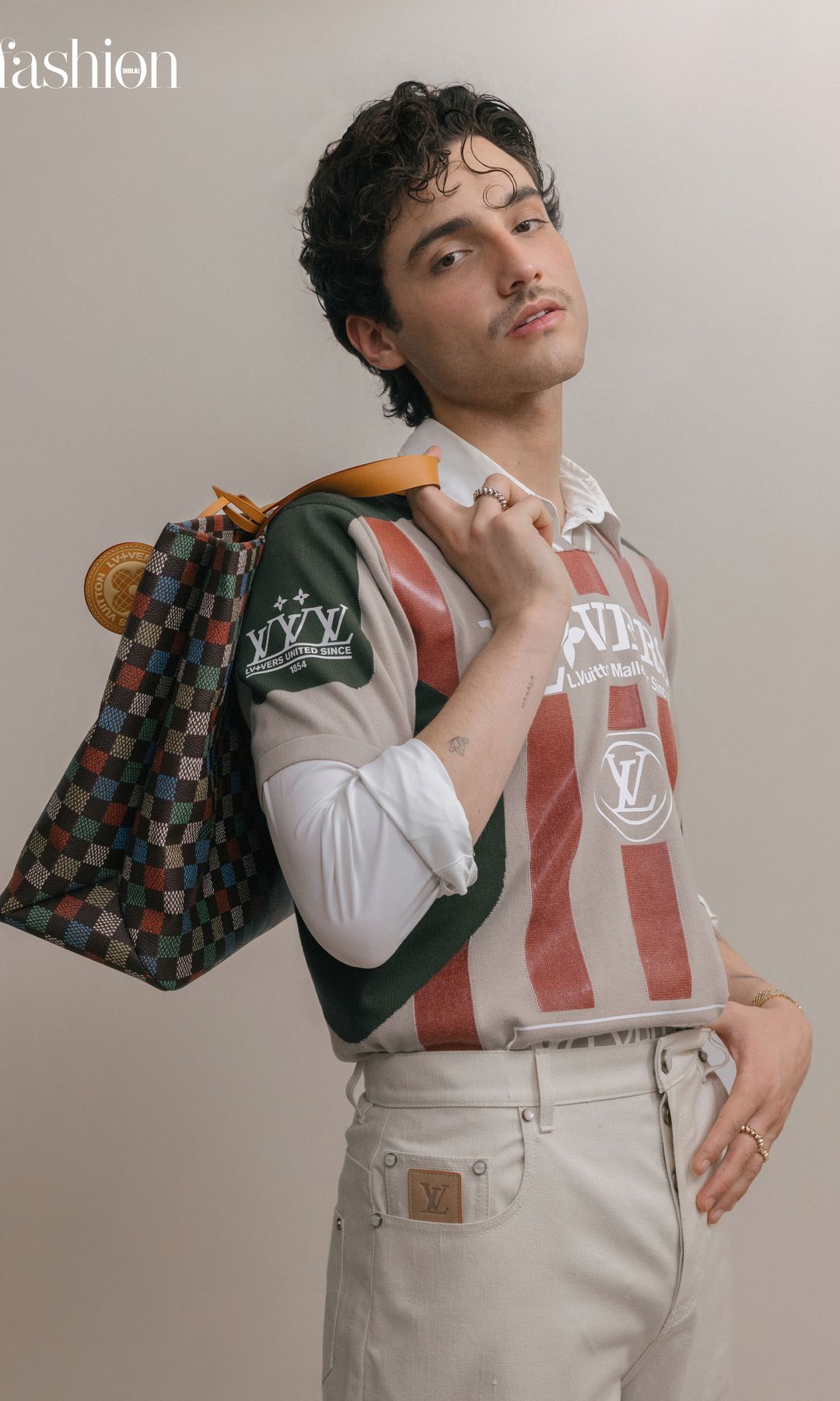 Sobre estas líneas, HUMBE demuestra su estilo moderno y sofisticado con un total look de inspiración deportiva de la colección primavera-verano 2025 de Louis Vuitton y anillos «Clash» de Cartier. 