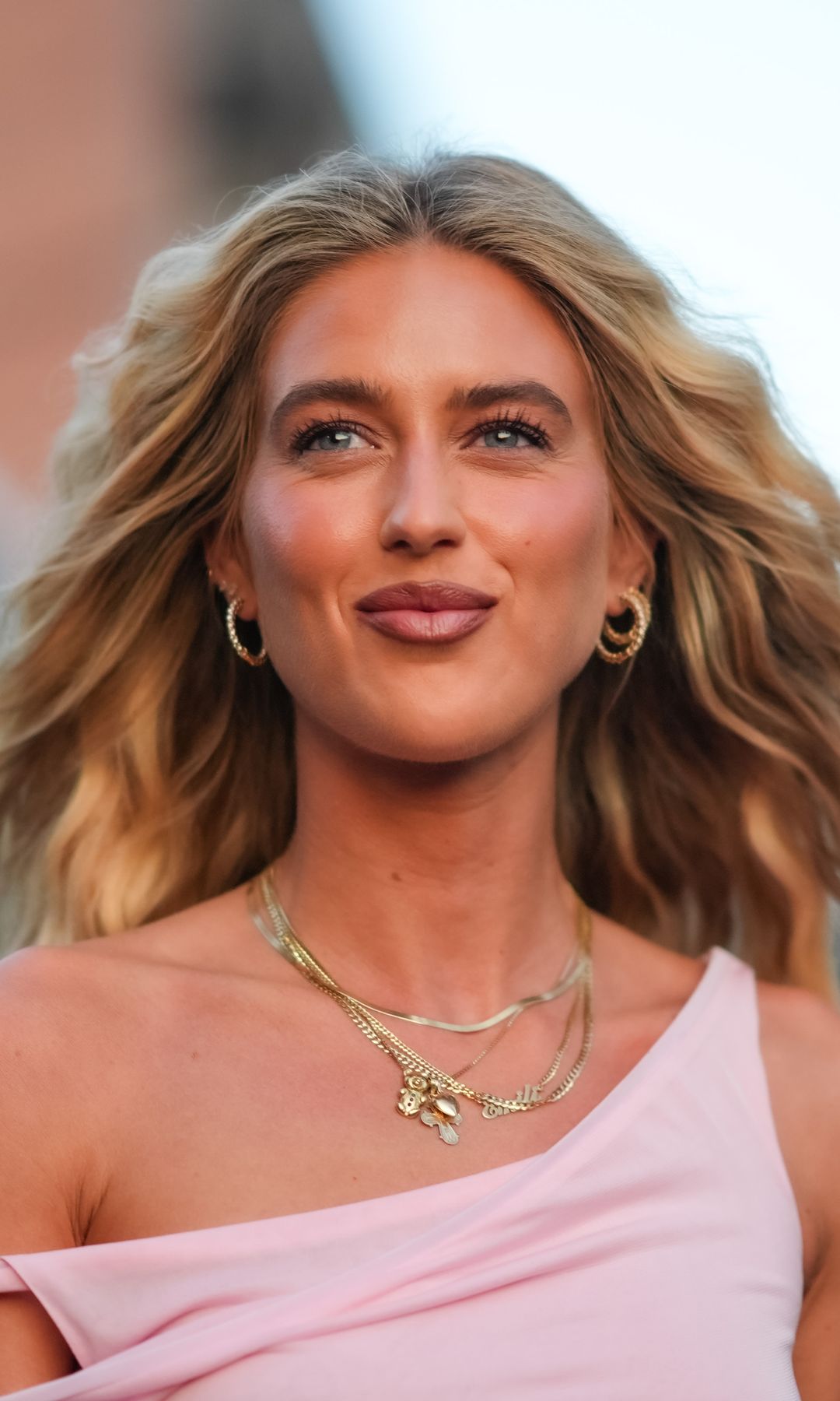 NEW YORK, NEW YORK - SEPTEMBER 09: Emili Sindlev wears earrings, gold layered necklaces, light pink off the shoulder Tory Burch mini dress, outside Tory Burch, during the New York Fashion week Spring/Summer 2025 on September 9, 2024 in New York, New York