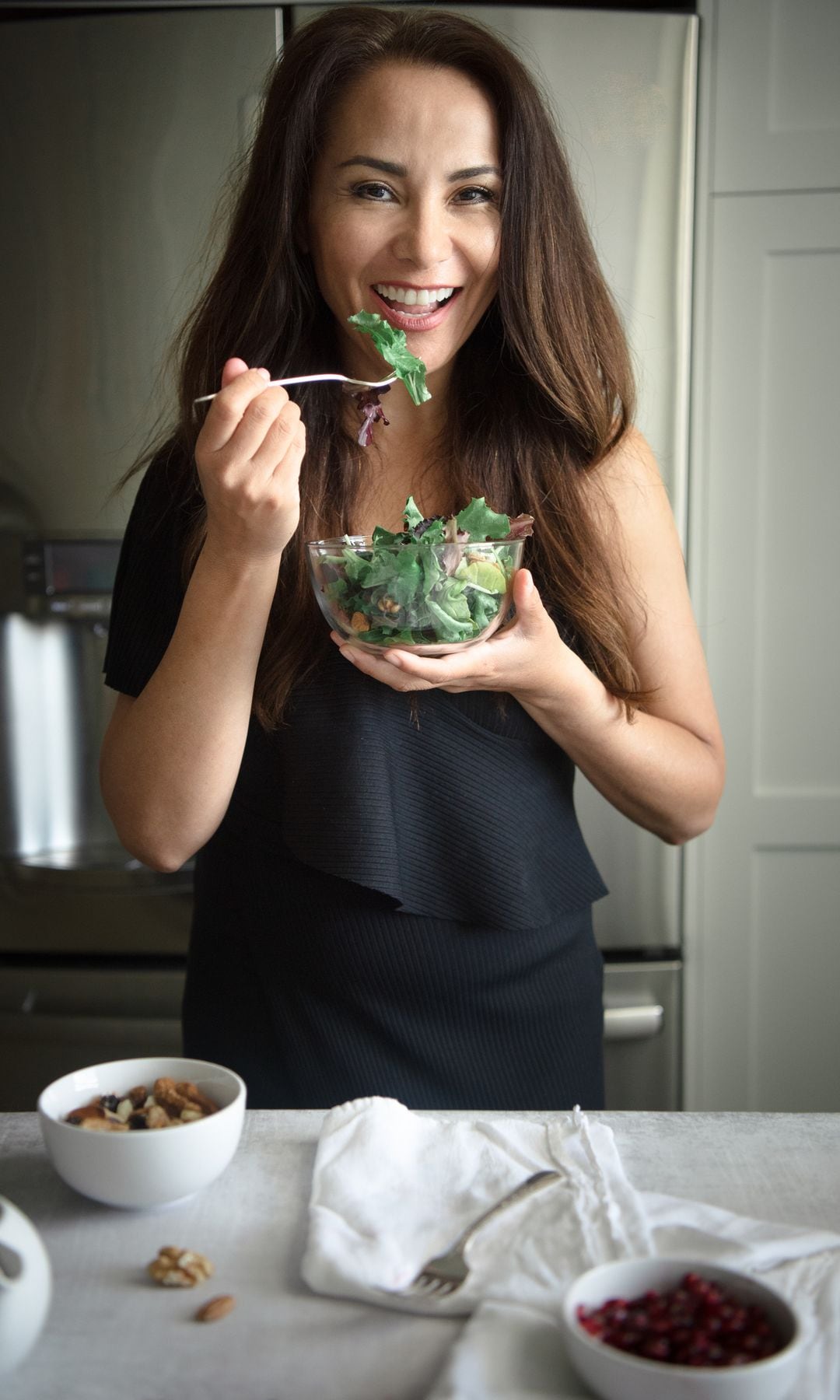 Una mujer comiendo una ensalada con sardinas para reducir la hinchazón durante la menopausia