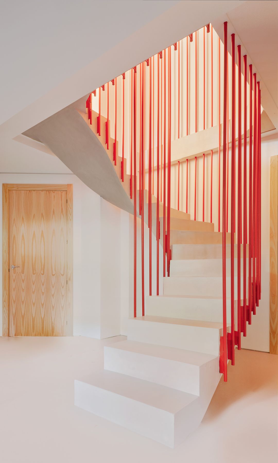 Escalera con escalones blancos y barandilla escultura roja