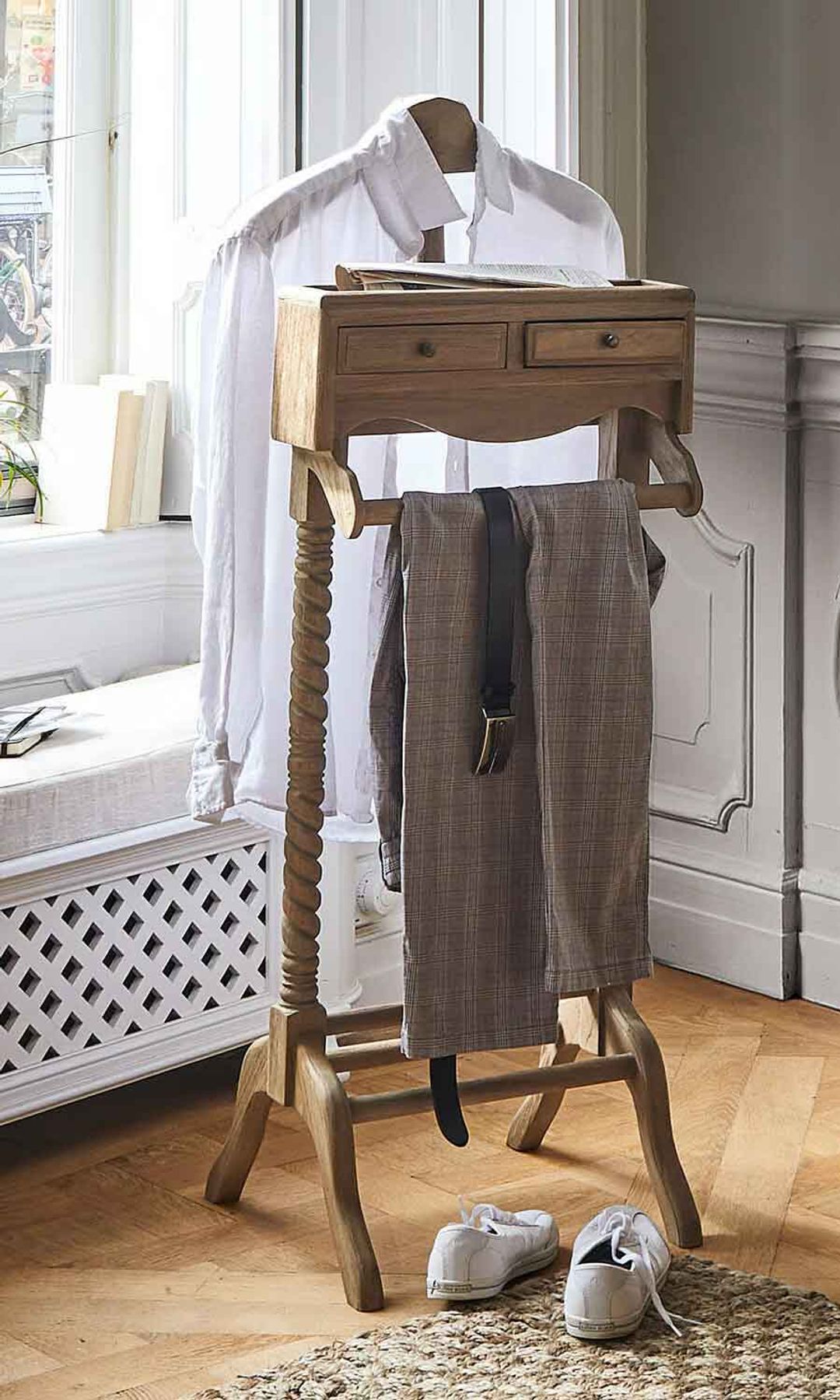 Dormitorio con galán de noche de madera con camisa blanca colgada 