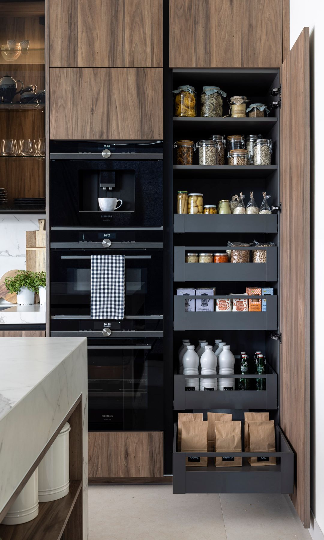 Despensa abierta en columna con cajones negros, muebles de cocina de madera