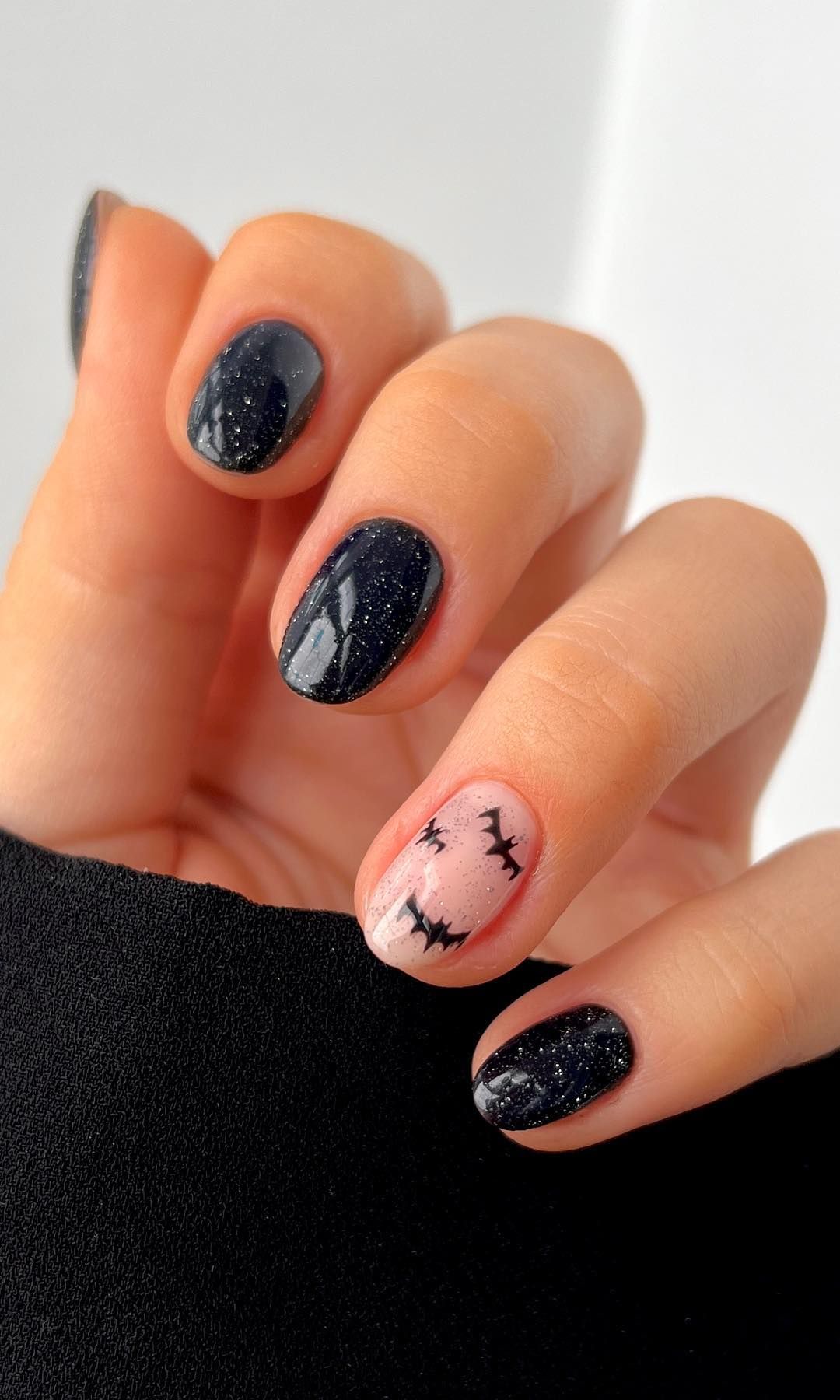 Manicura nagra con brillos y murciélagos