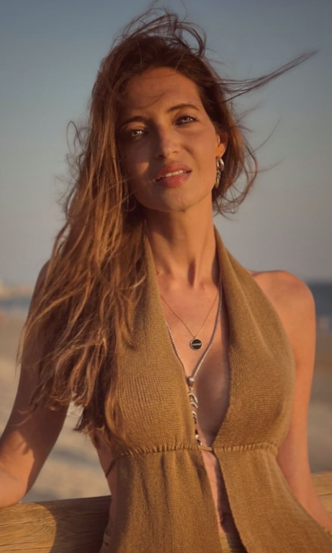 Sara Carbonero en la playa con conjunto en tonos tierra, el pelo despeinado y la piel bronceada