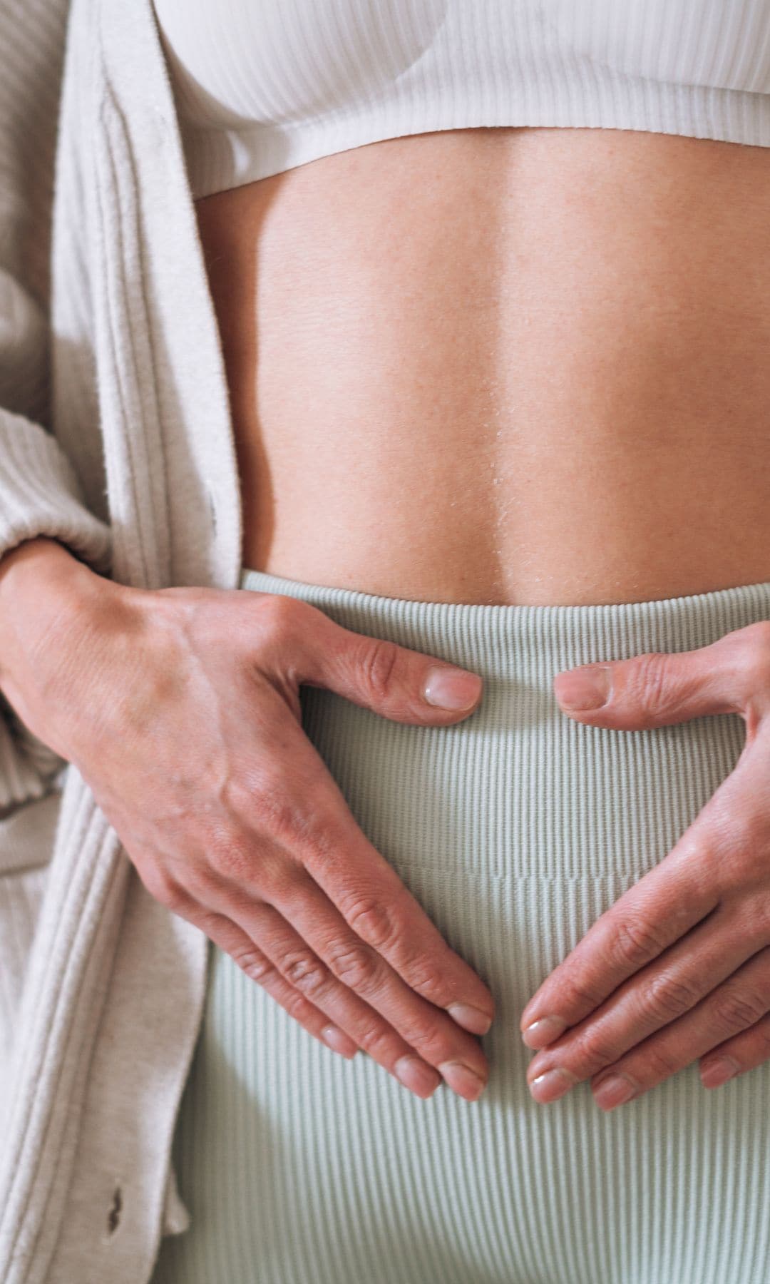 Una mujer con ropa deportiva y el abdomen plano