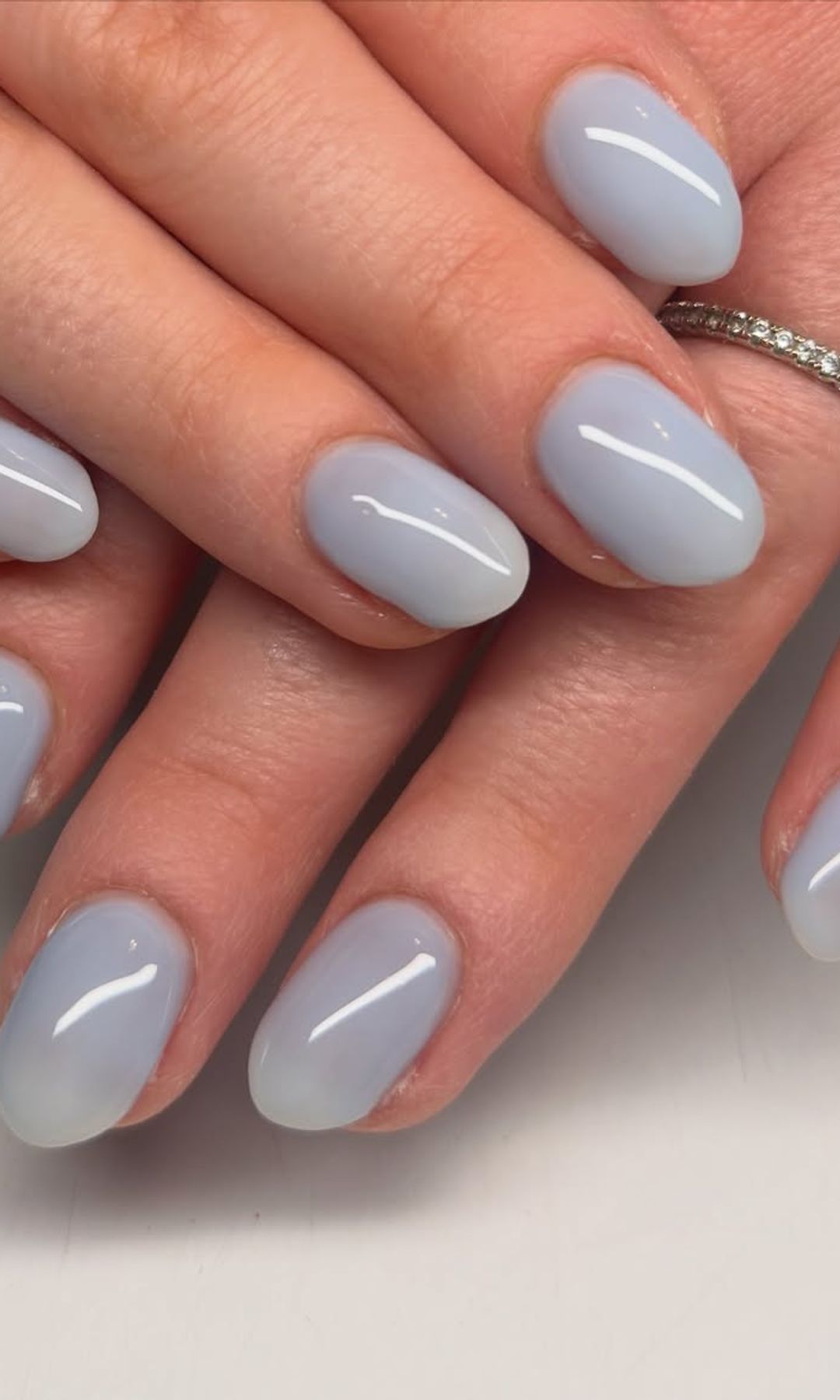 Manicura azul claro con acabado brillante en uñas ovaladas