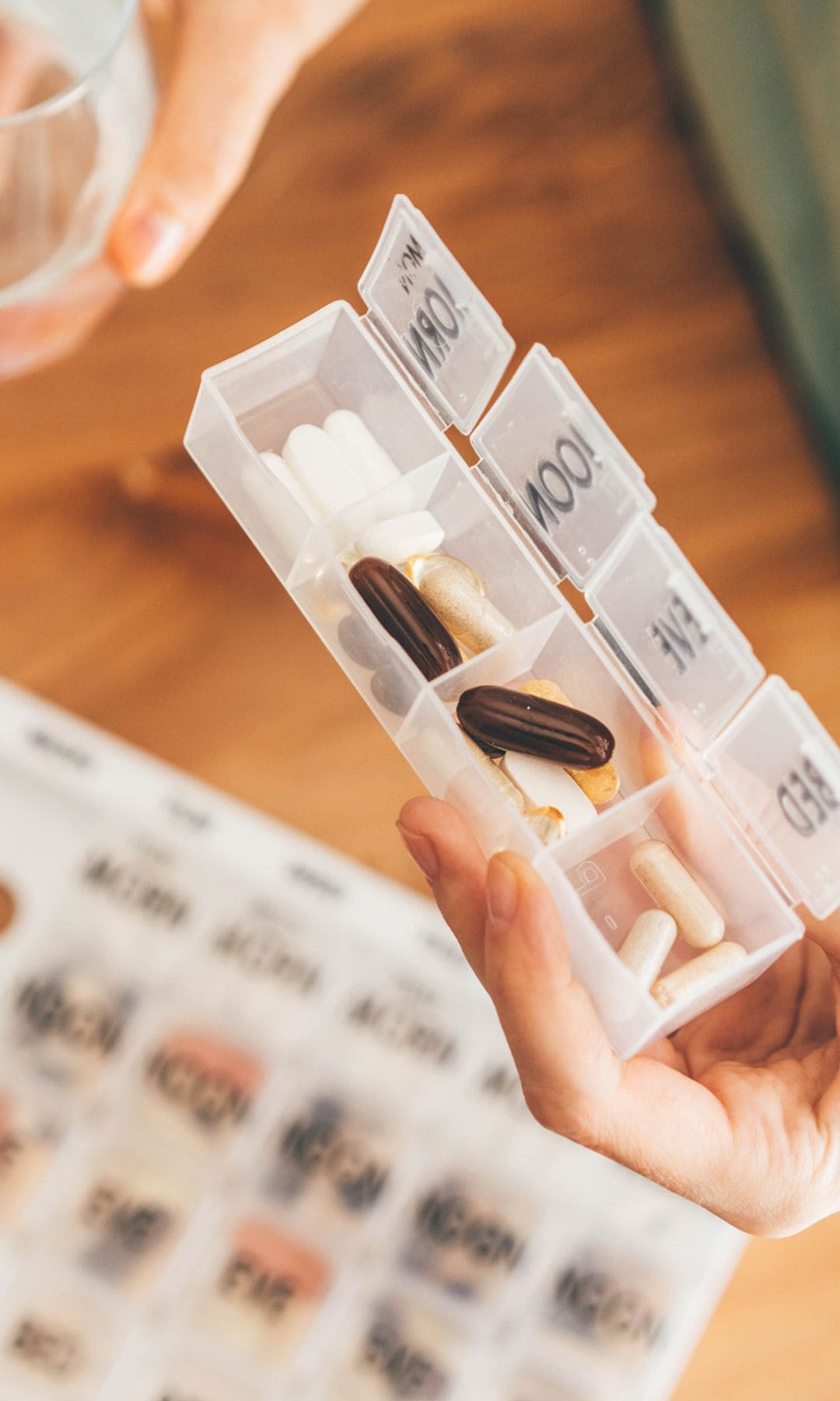 Pastillero semanal en las manos de una mujer