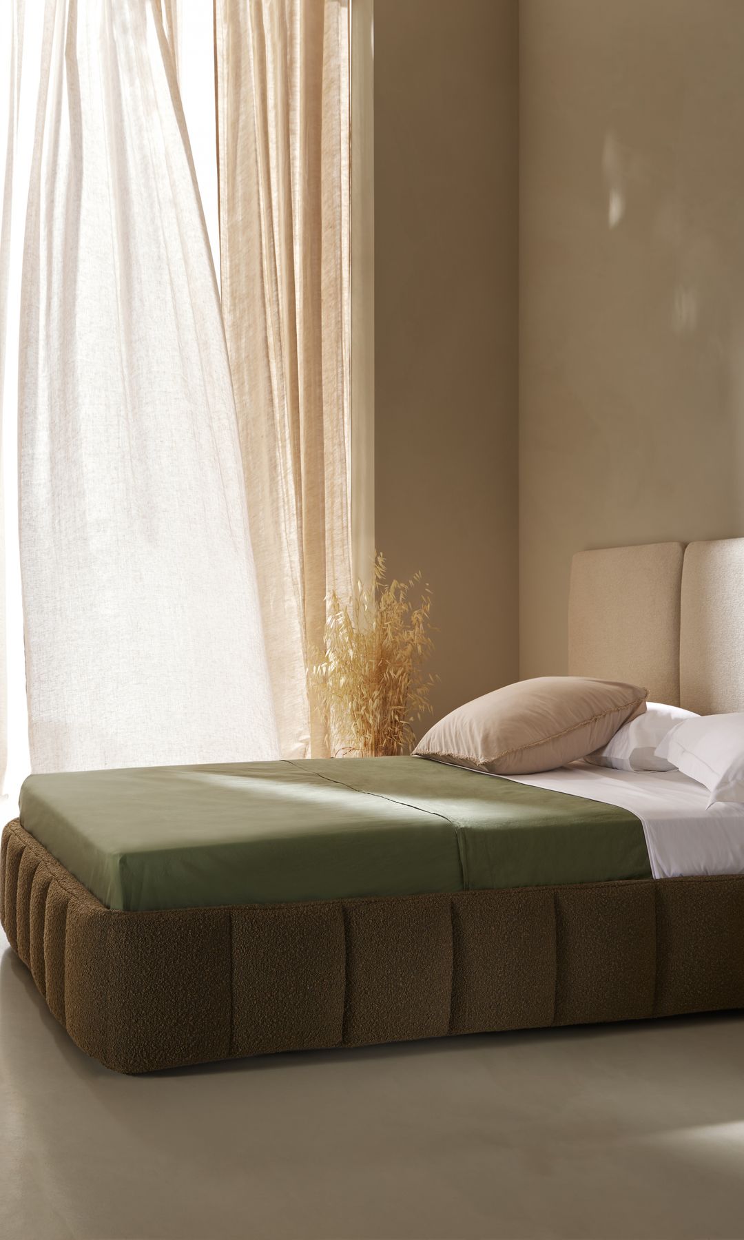 Dormitorio con cama abatible y cabecero tapizado modular con cortinas beiges 