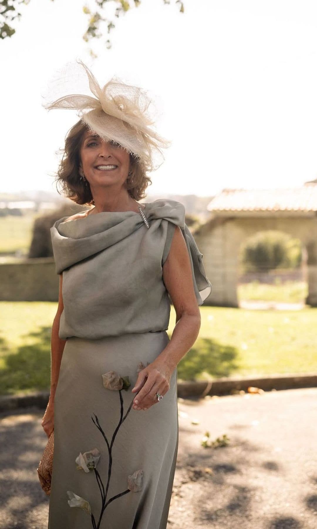 María, una madrina con vestido verde grisáceo con flores, de Sole Alonso, y tocado de rafia de Mimoki