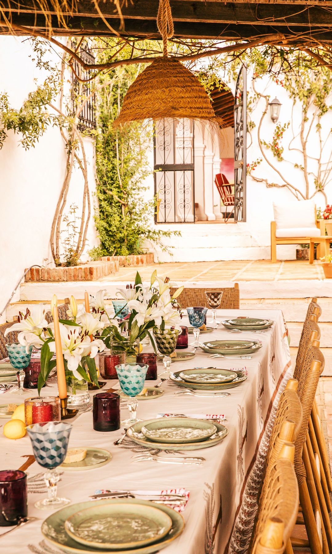 La elegante mesa dispuesta en el exterior de la casa, con sillas Eicholtz y servilletas y mantel Bloom Paris. "Organizamos todo alrededor de largas cenas deliciosas, con mesas cuidadosamente decoradas, donde hablamos de nuestras vidas y de nuestra pasión por la gastronomía. También invitamos a nuestros invitados a practicar yoga o a acompañarnos a dar de comer a nuestros burros y caballos", añade nuestra anfitriona