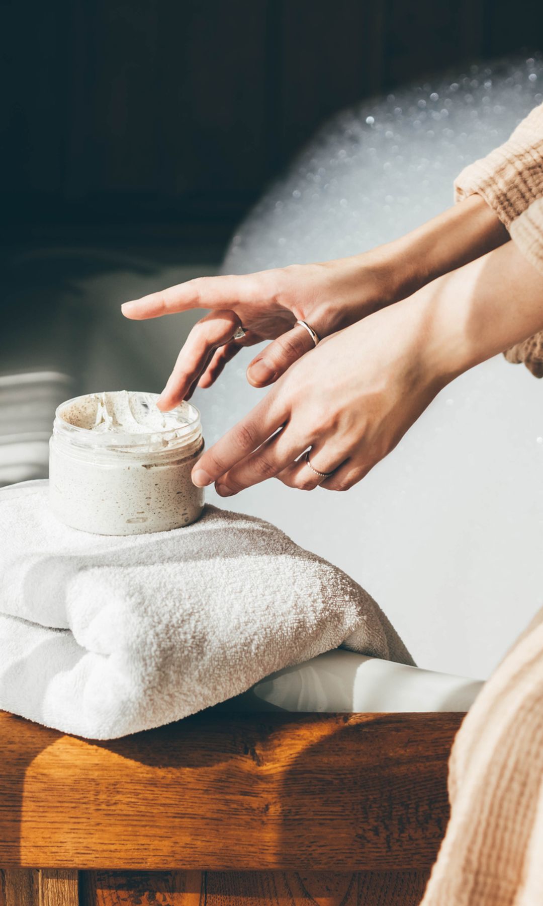 Una mujer aplicándose crema después de la ducha
