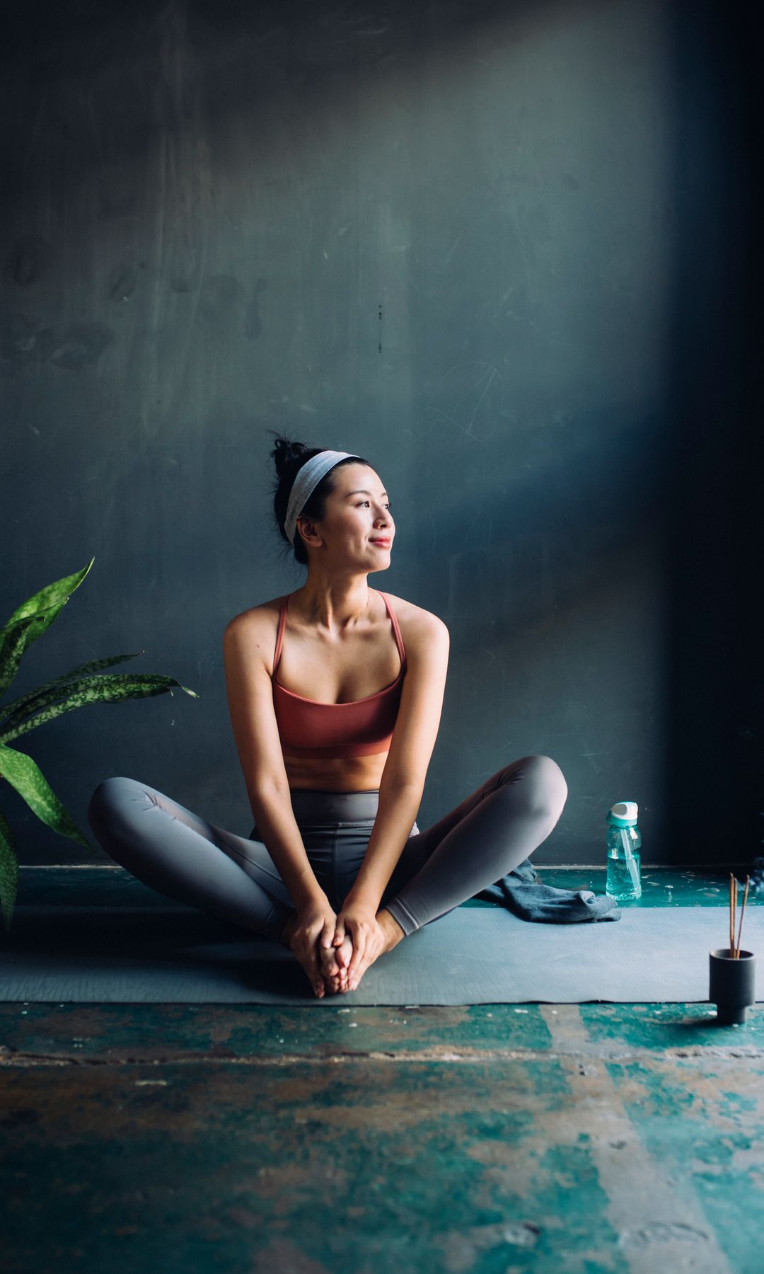 Mujer haciendo yoga sobre una esterilla con las piernas en mariposa