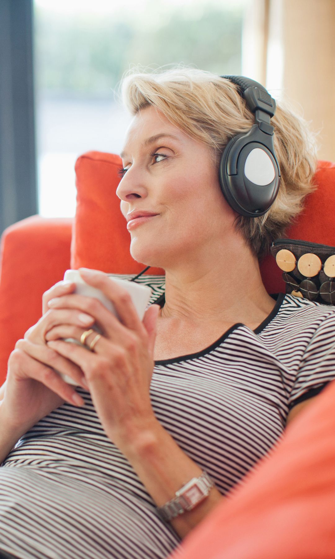 Mujer relajada en un sofá escuchando música 