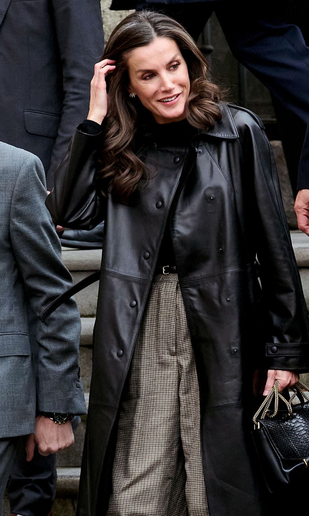 La reina Letizia con gabardina negra y bolso