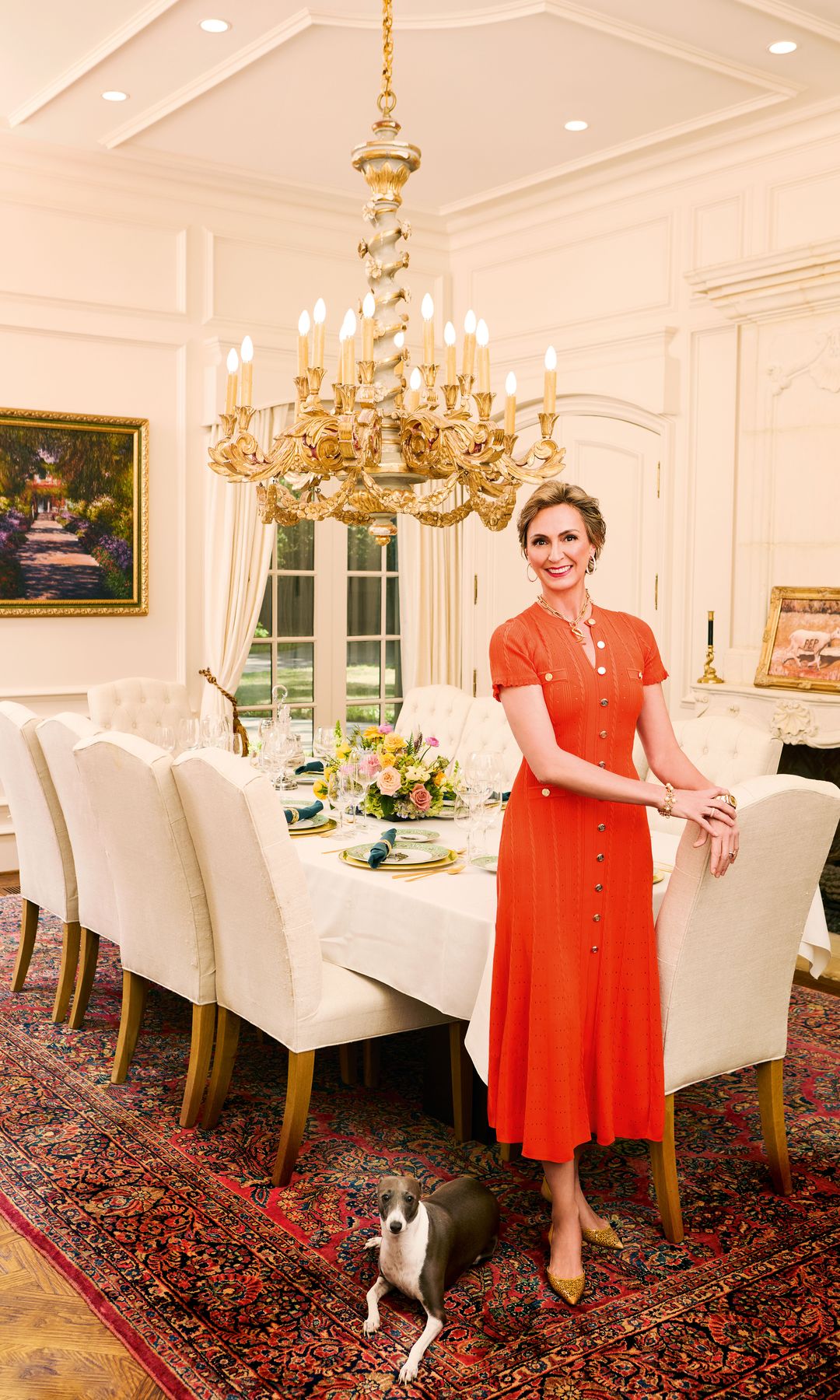 Raquel, que es presidenta de la Casa de España en Dallas/Fort Worth, posa junto a uno de sus galgos en el comedor, elegante y de estilo clásico. 