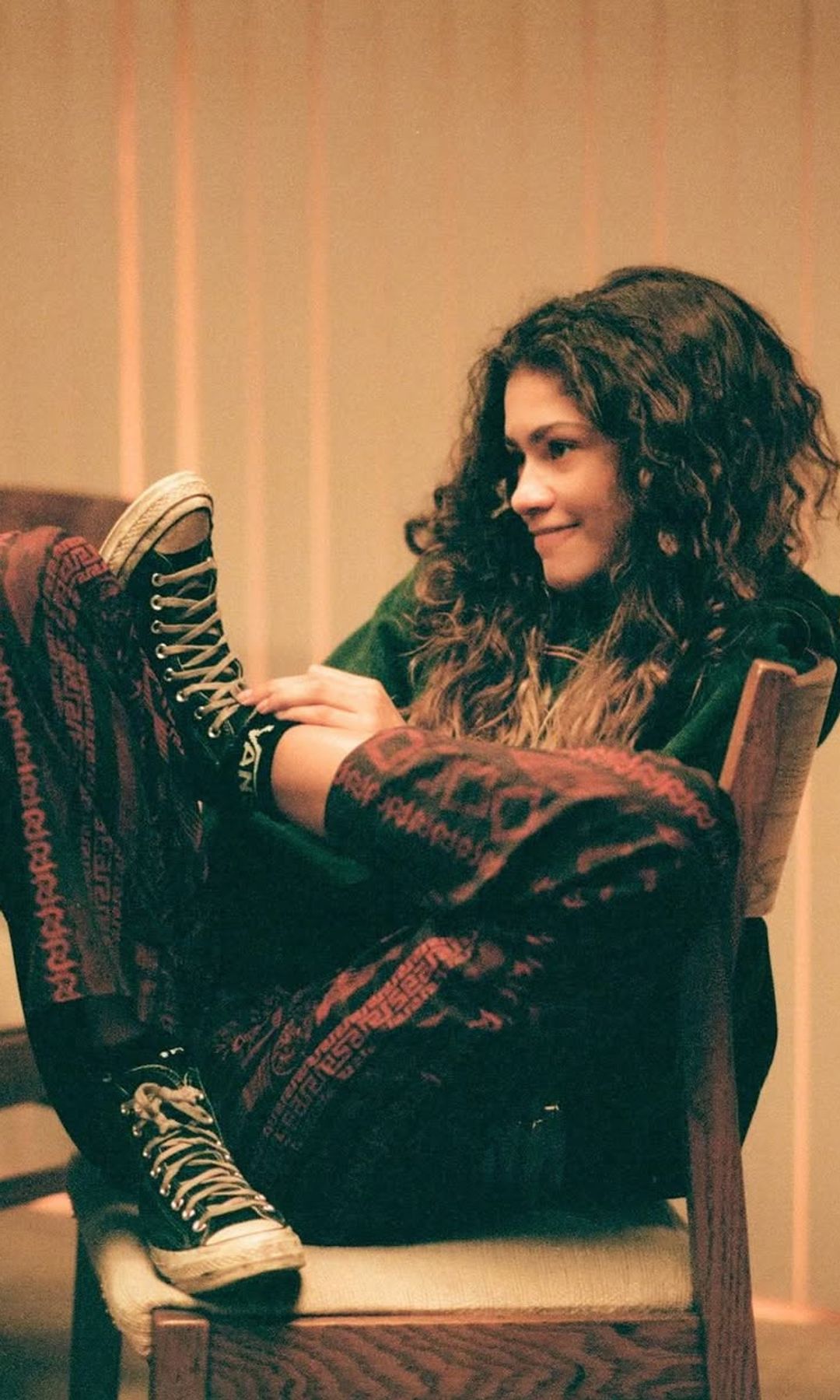 Zendaya sentada en una silla con unas converse