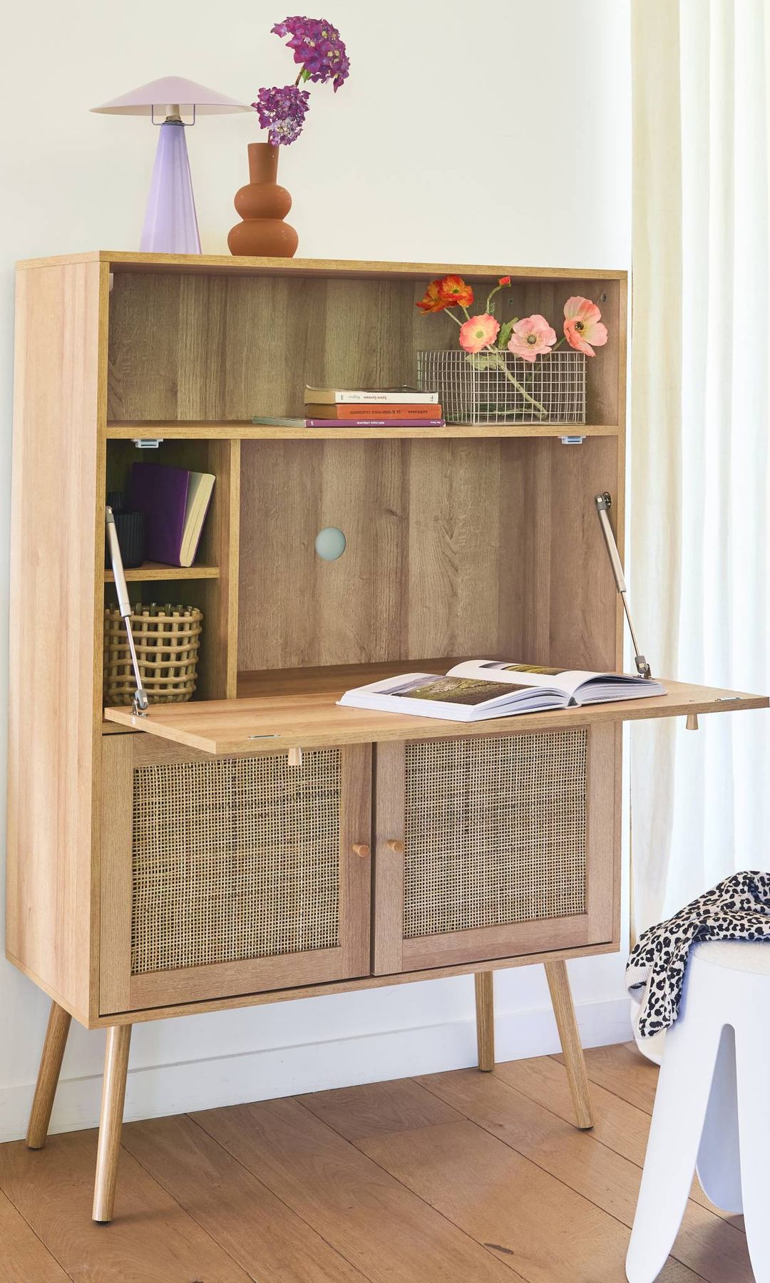 Secreter de madera con puertas inferiores de rejilla, tablero abatible y taburete blanco