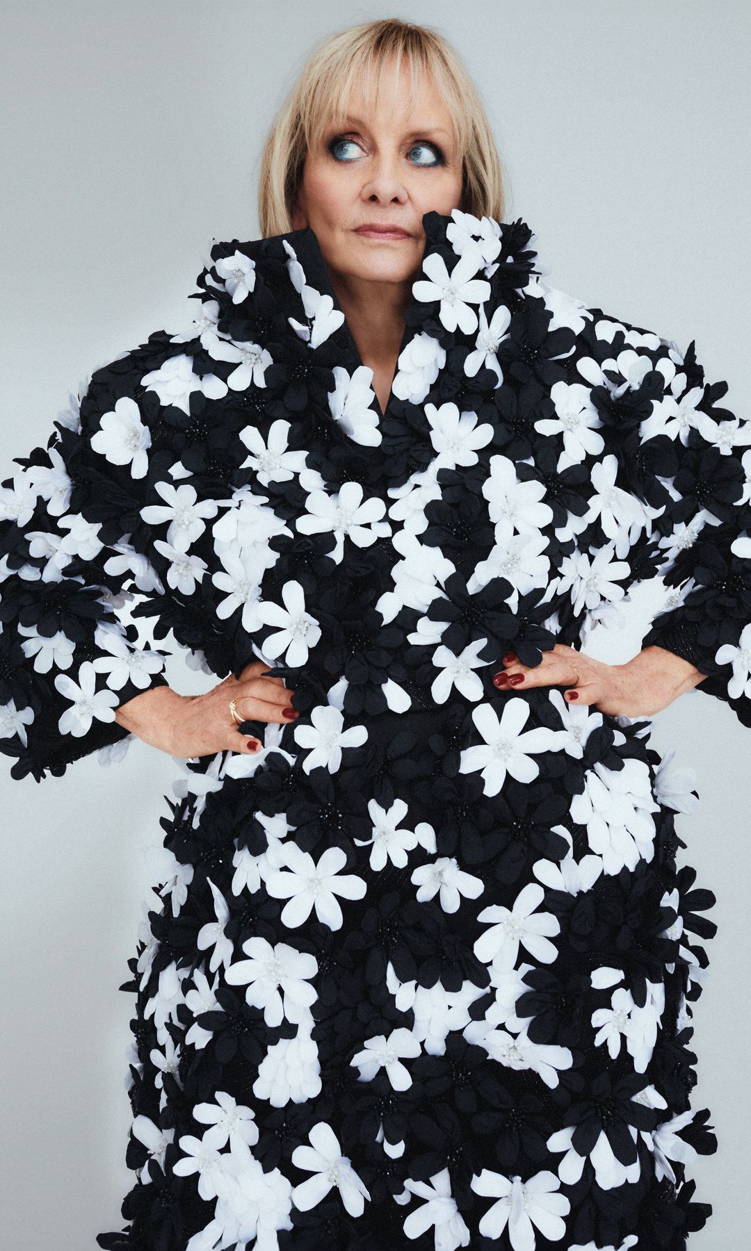 Twiggy con abrigo negro con flores blancas