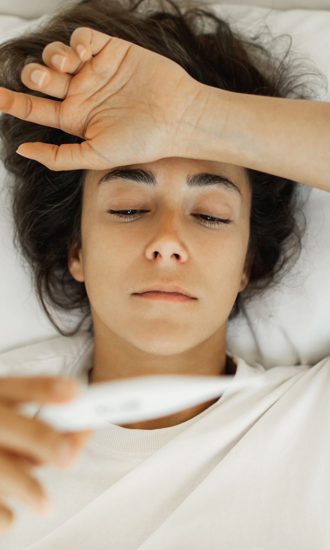 Mujer tumbada en la cama con fiebre