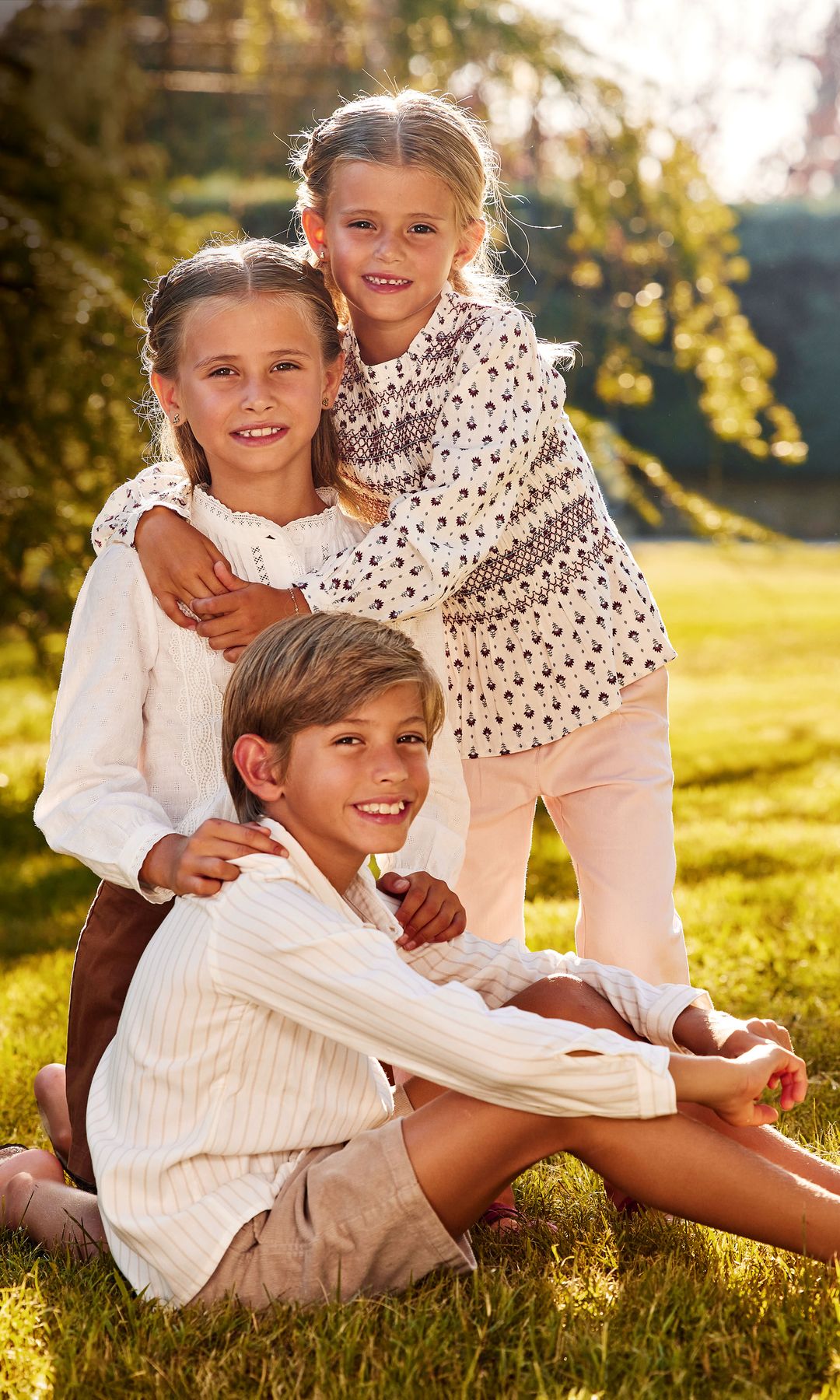Sus tres amores: Markuss, con pantalón corto de pana, de Coconut El Corte Inglés, y camisa de Nanos; Liene, minifalda de Tommy Hilfiger Kids y blusa blanca de Coconut El Corte Inglés, al igual que su hermana, Álisse, que posa con pantalones de Nanos