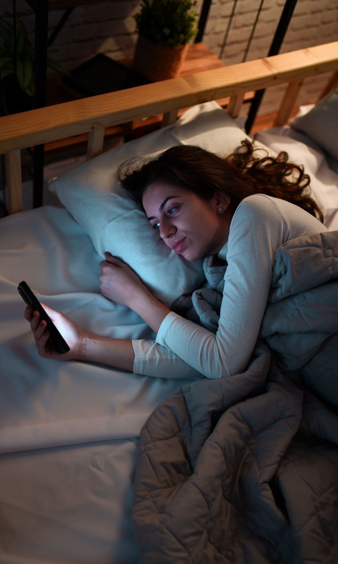 chica mirando el movil en la cama