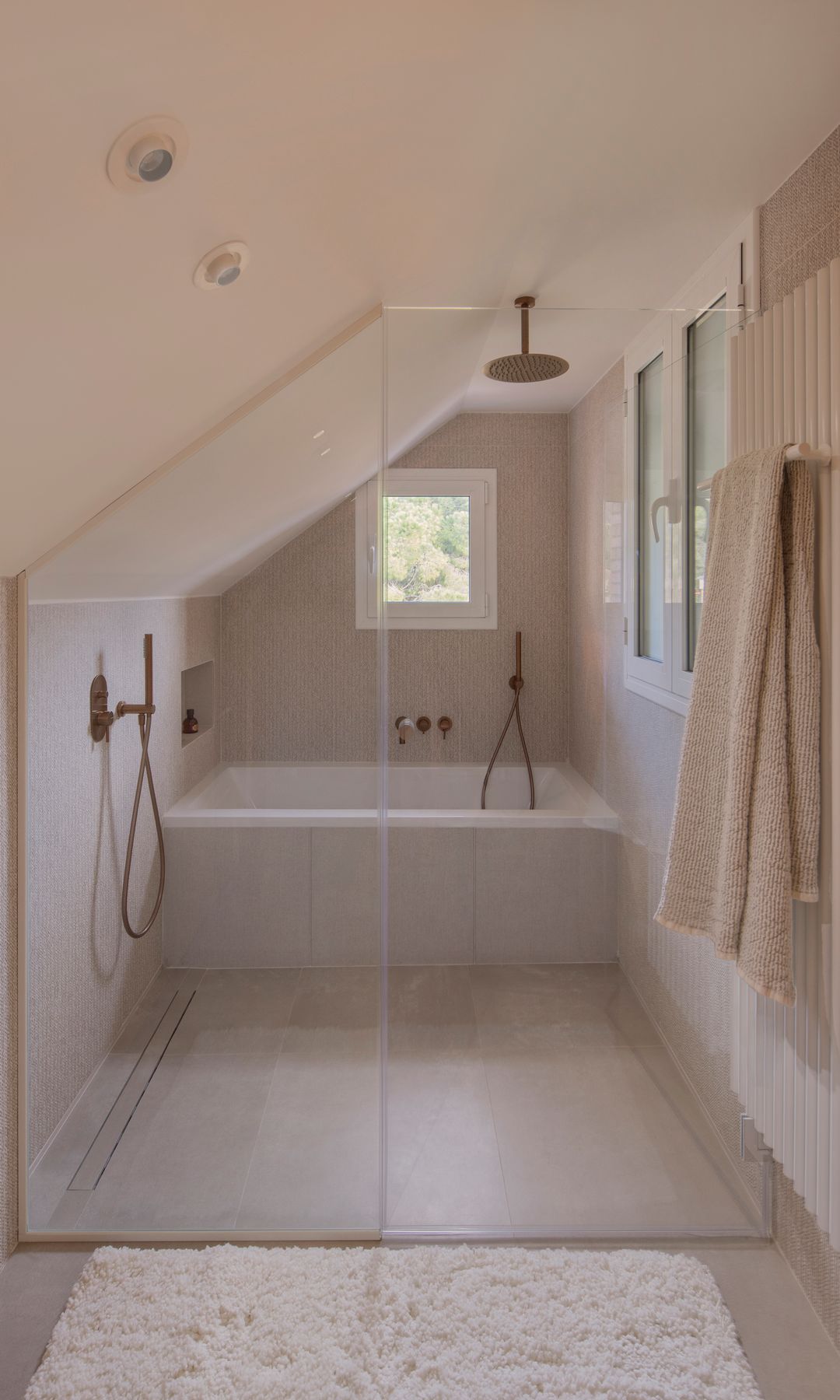 Baño abuhardillado con bañera y ducha en cabina, puertas de cristal 