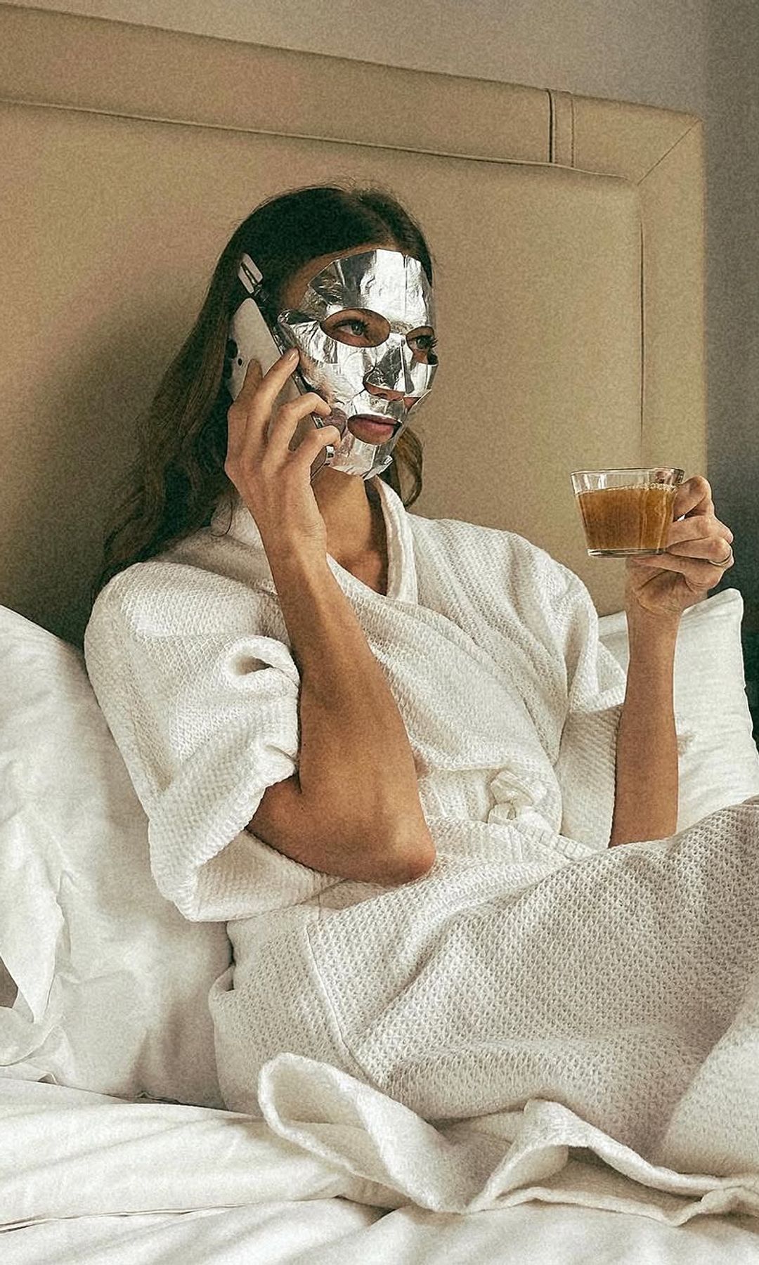 La modelo Karlie Kloss en la cama con su mascarilla facial y su café