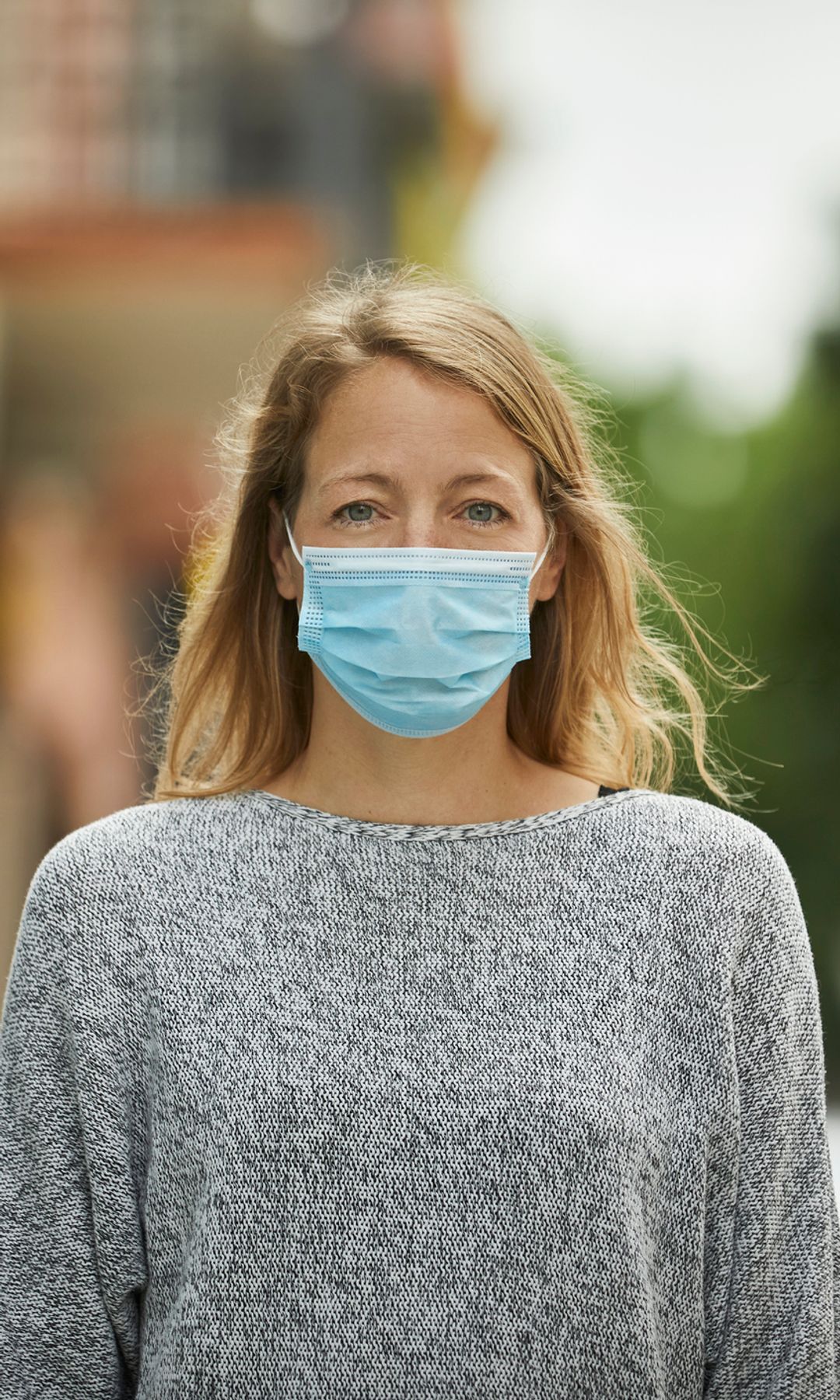 Mujer en la calle con mascarilla quirúrgica 