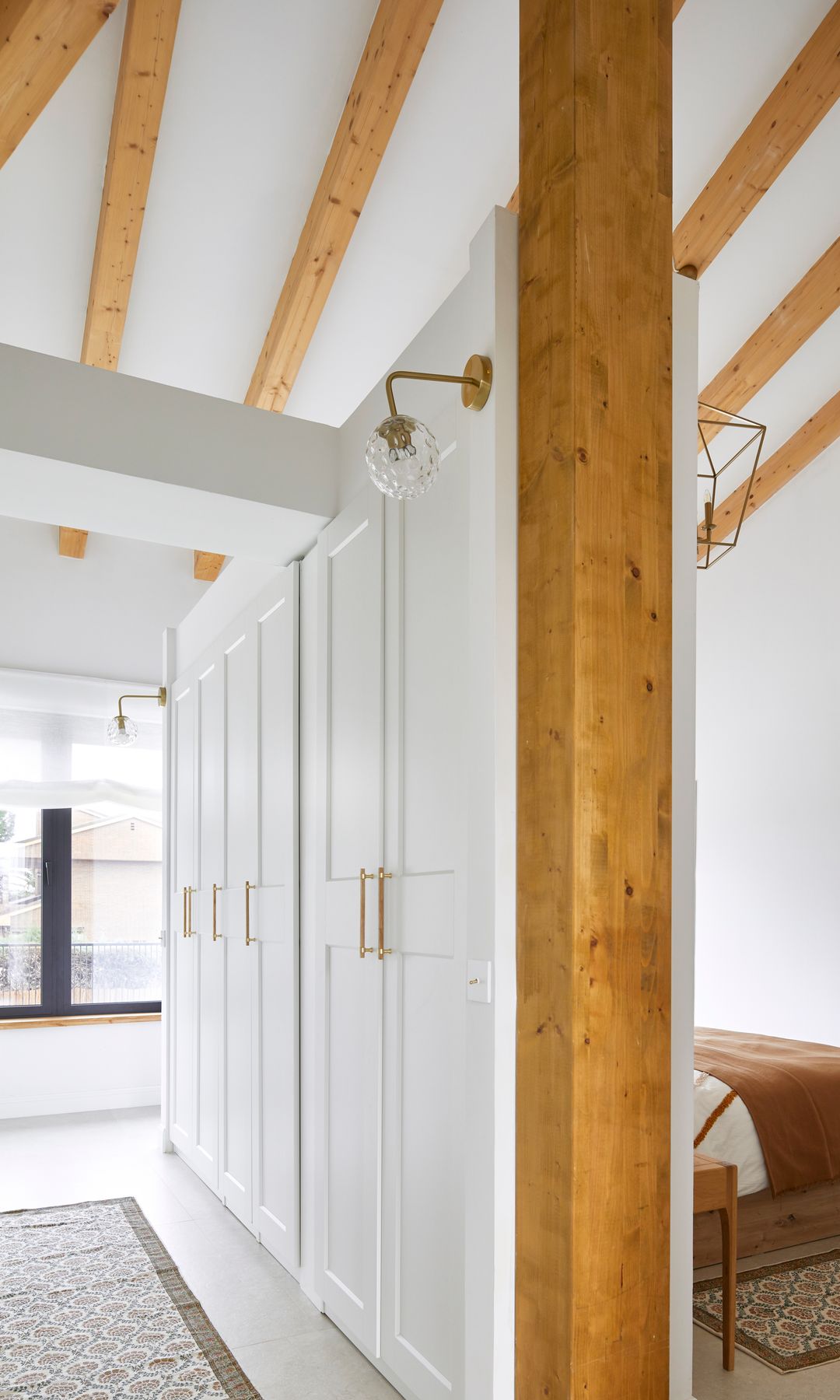 Dormitorio con vestidor y vigas en el techo, diseño de Montse Morales