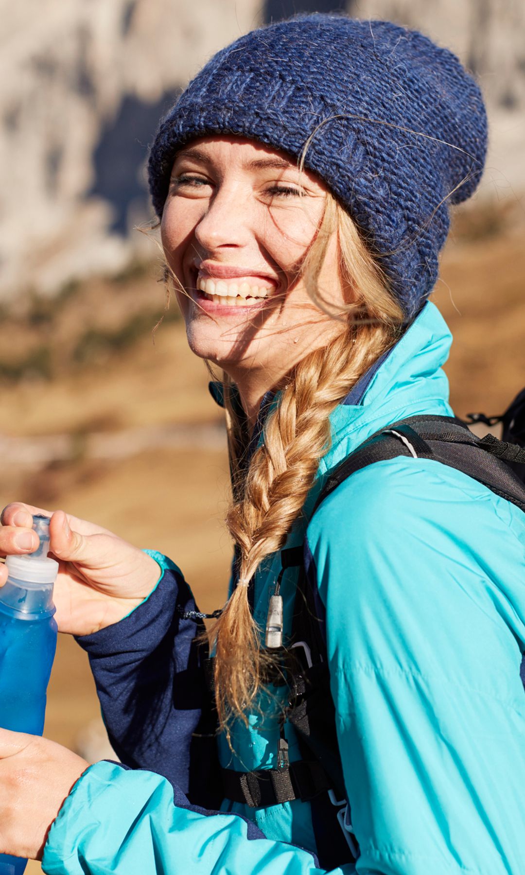 Mujer feliz caminando por la montaña