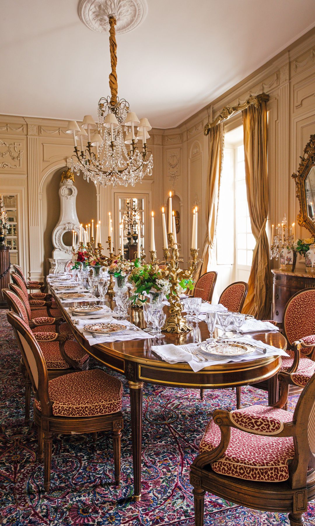 Comedor con mesa larga, sillas de leopardo, candelabros y flores