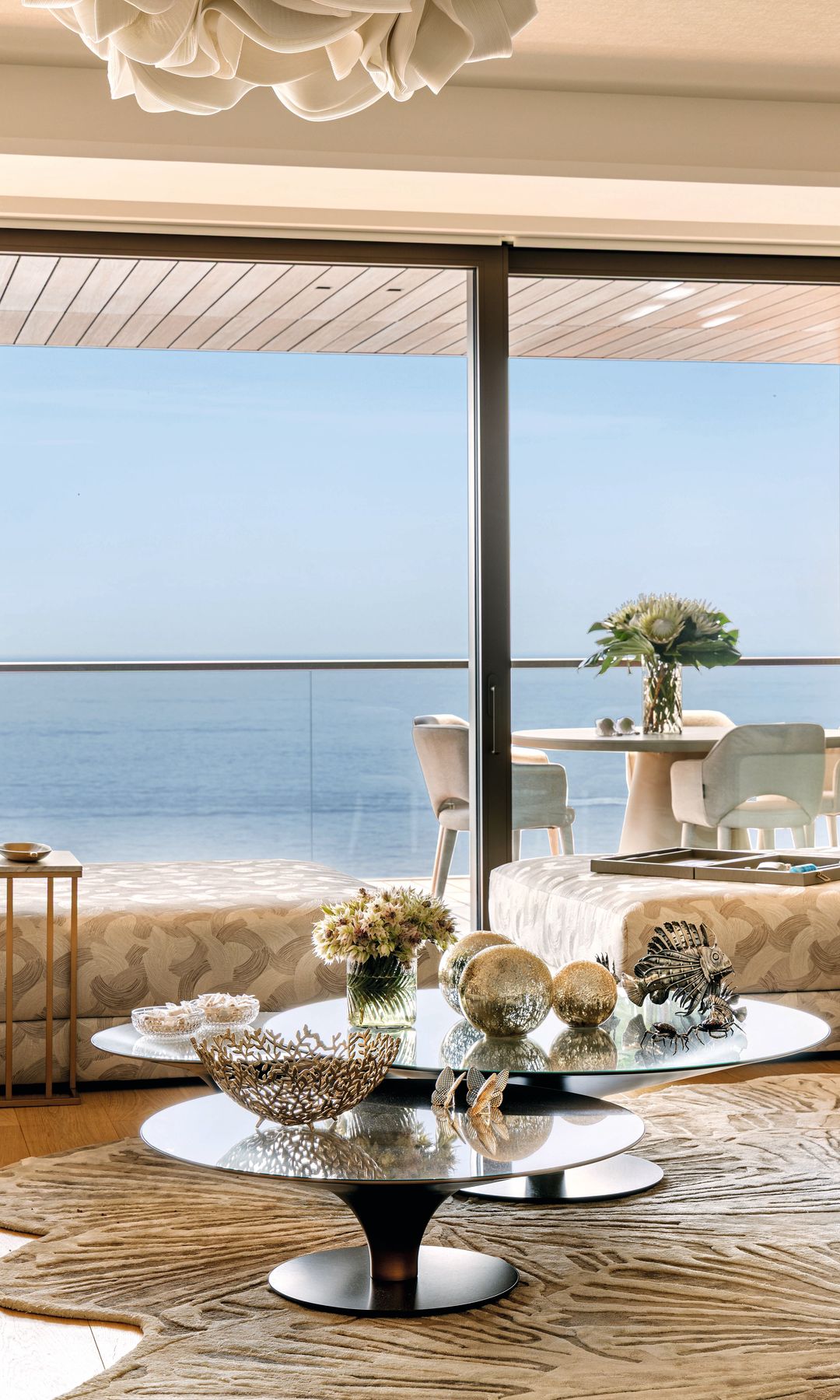 Vistas desde el salón a la terraza exterior y su mesa, y de fondo el mar