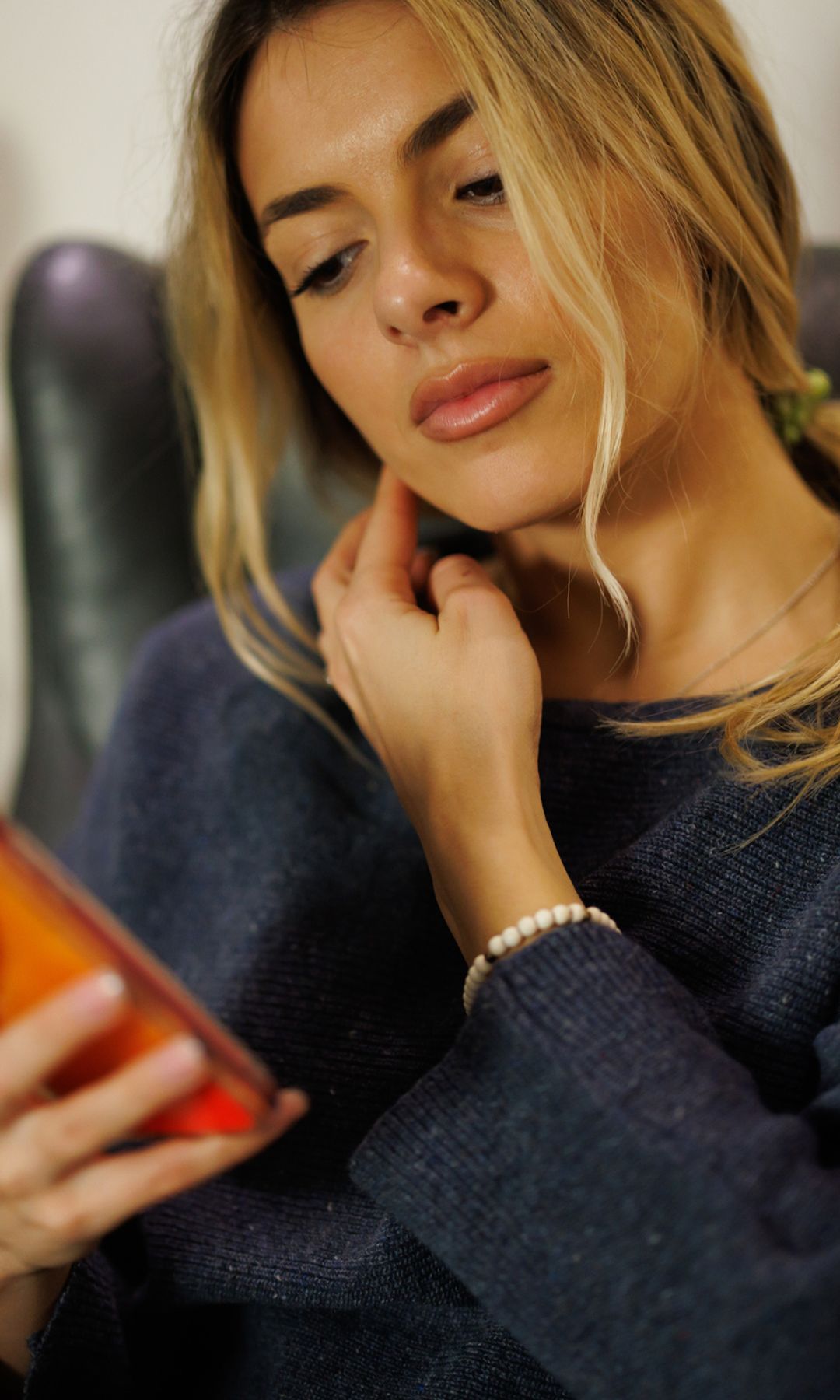 Mujer rubia con el móvil en la mano 