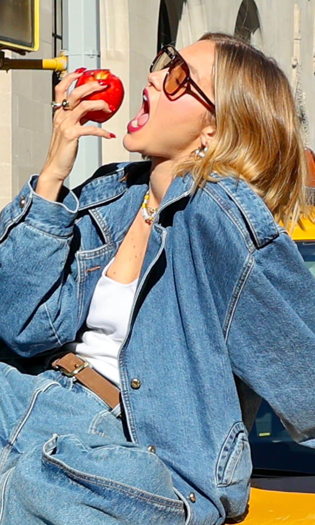Gigi Hadid en Nueva York con look vaquero comiendo una manzana