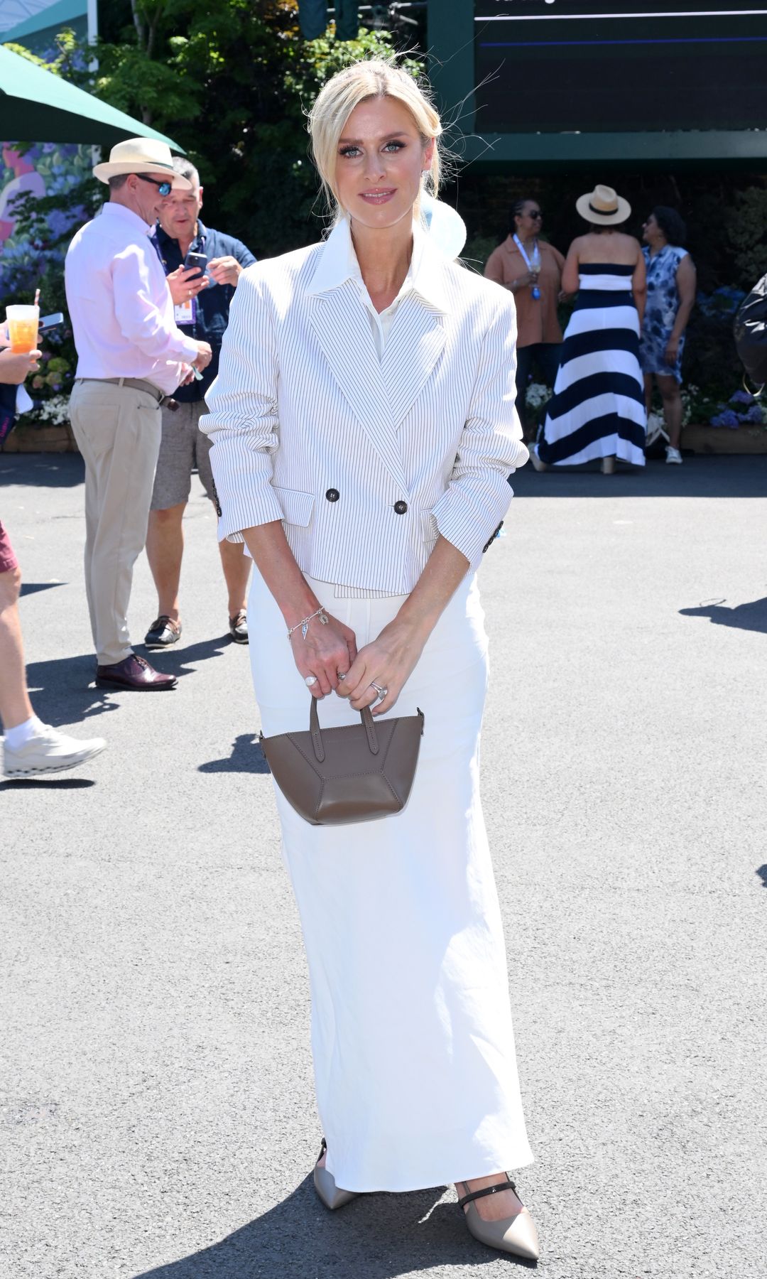 Nicky Hilton Rothschild en la final femenina de Wimbledon 2025, con blazer corta a rayas un vestido blanco, muy a tono con la estética del torneo