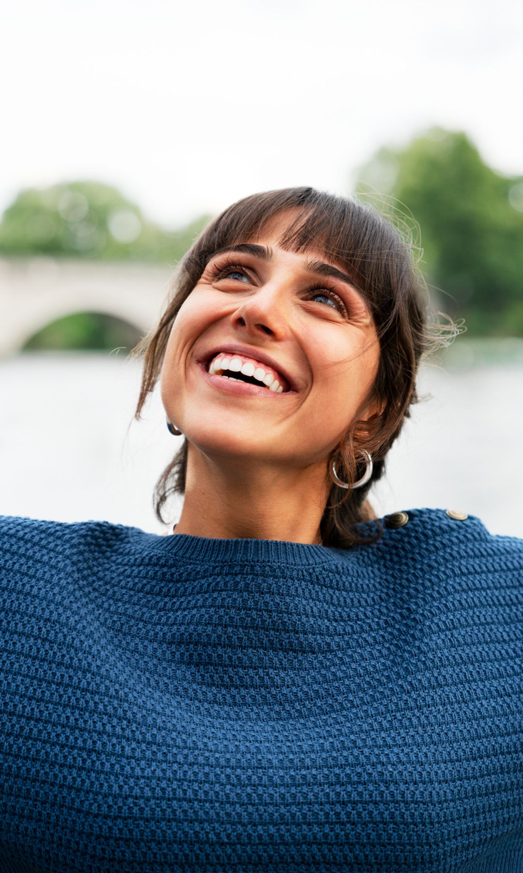 Mujer feliz mirando al cielo con los brazos abiertos con gesto de agradecimiento
