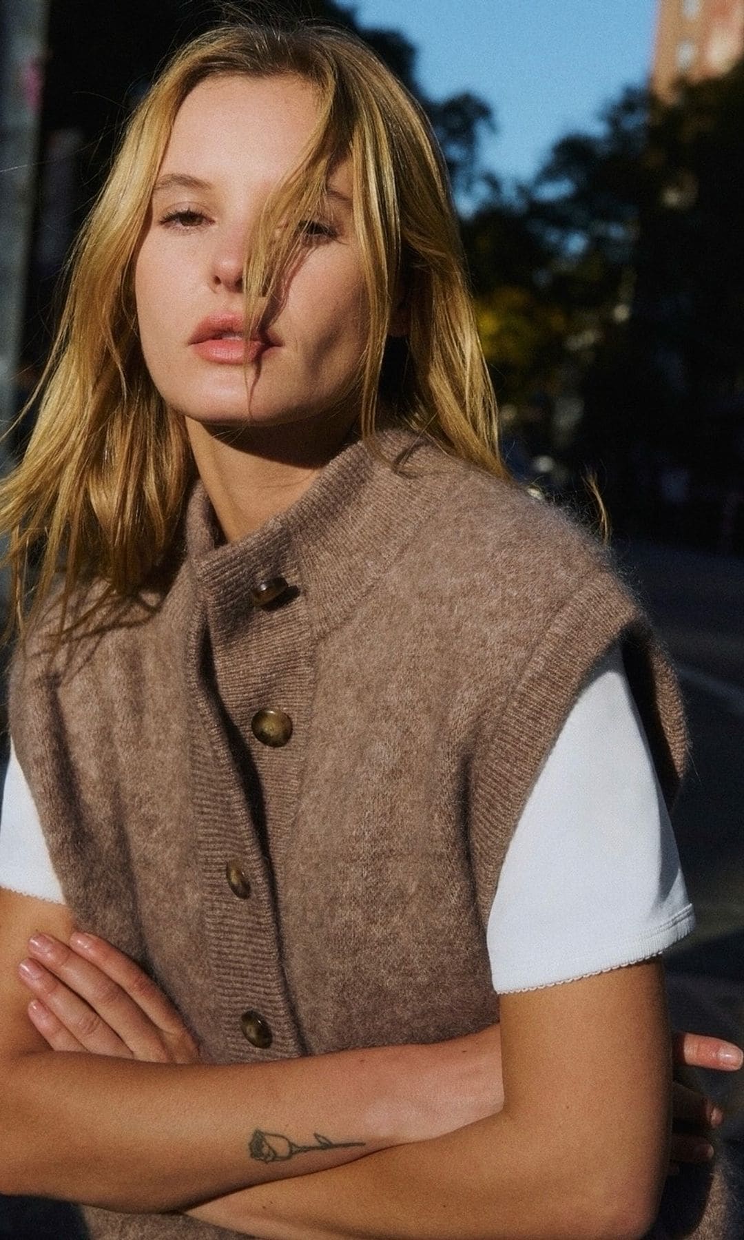 mujer con expresión relajada y natural al aire libre, look casual de otoño