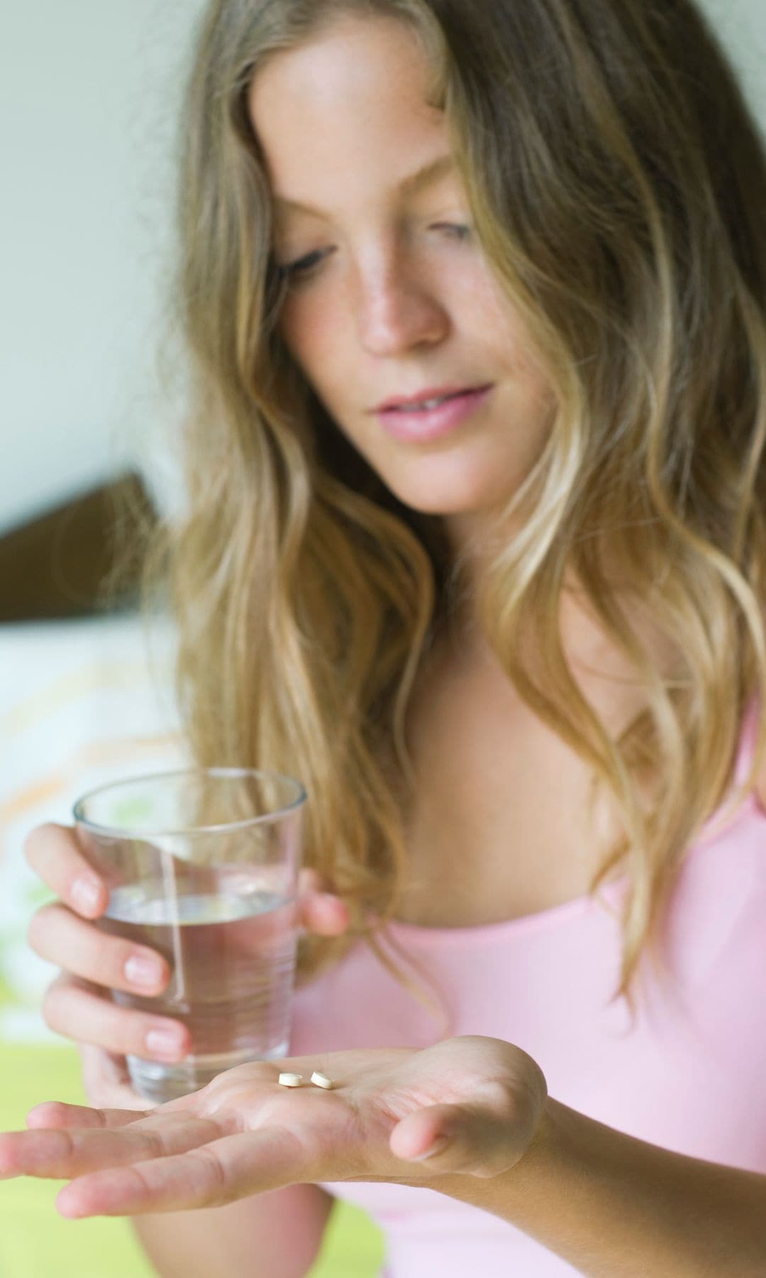 Una chica tomando sus suplementos alimenticios