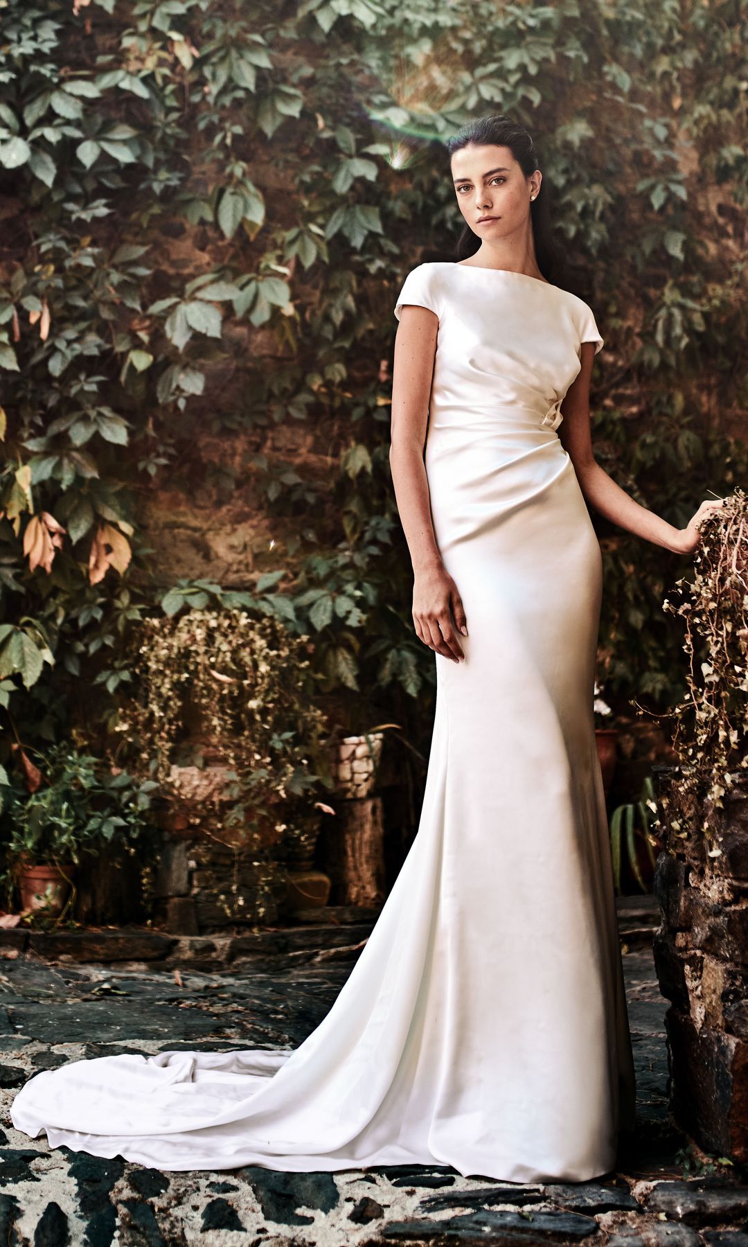 Efecto satinado: La sencillez no eclipsa a la sofisticación de este modelo, el vestido de novia recto Rimar, en crepé satén con cuerpo drapeado y manga caída