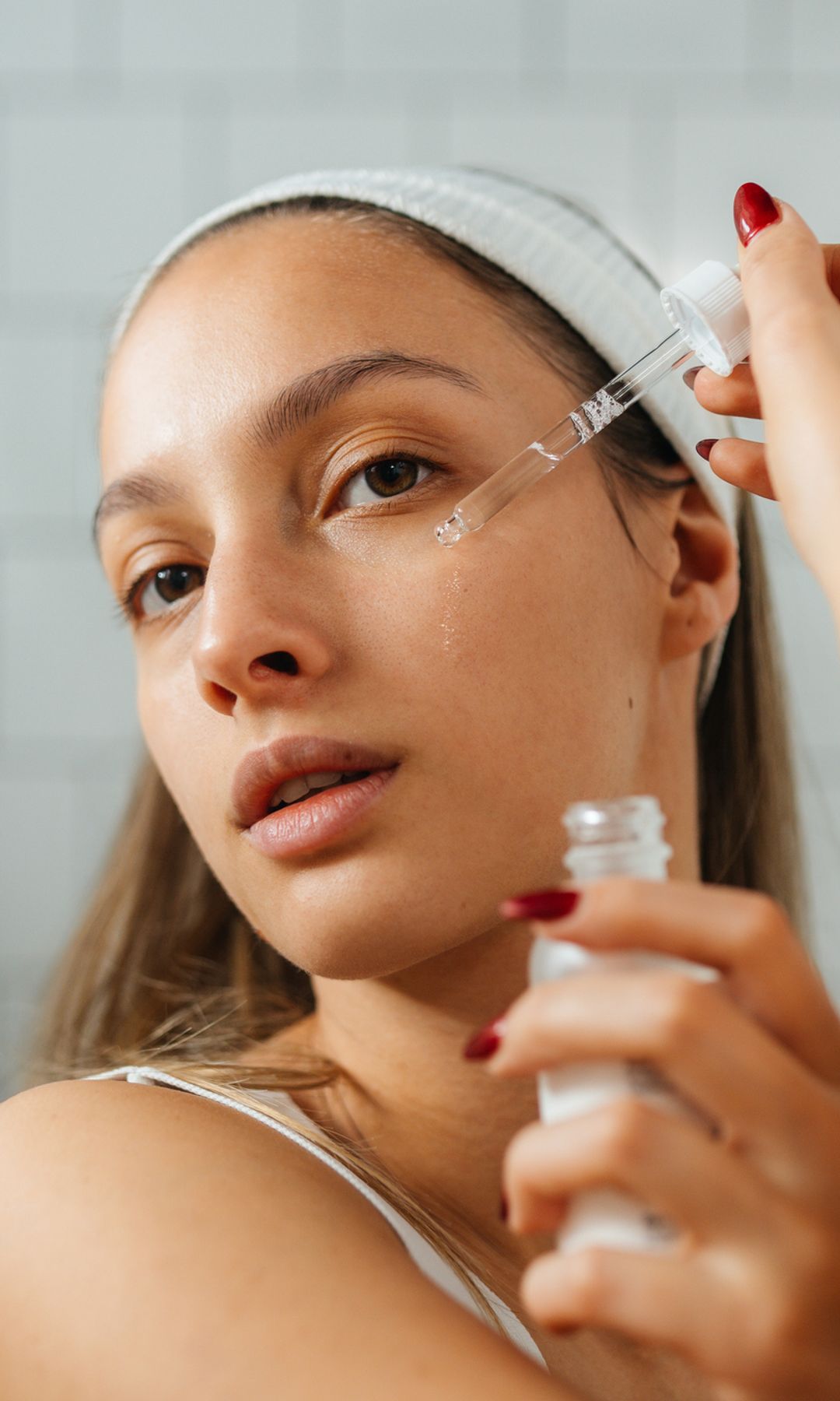 Una chica joven aplicándose sus productos de skincare