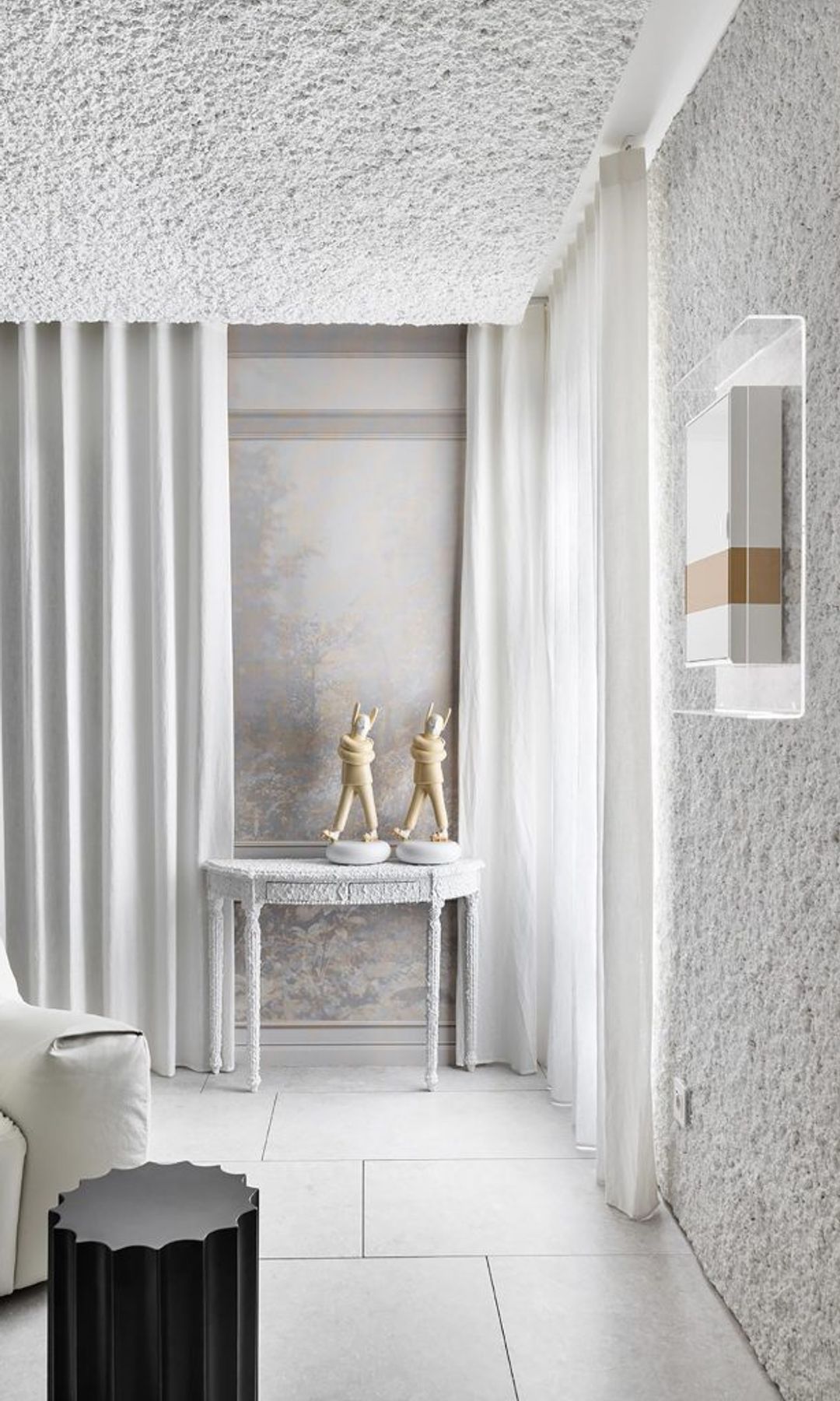 Salón con paredes y techo con gotelé blanco, cortinas blancas, sofá de cuero blanco 