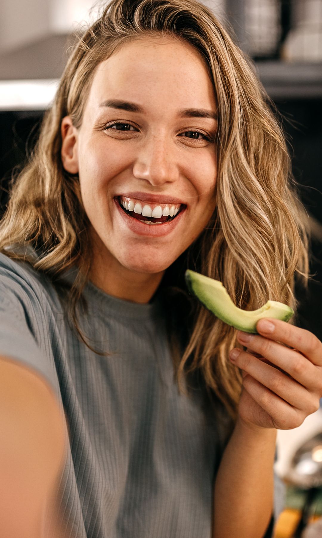 Mujer divertida comiendo aguacate