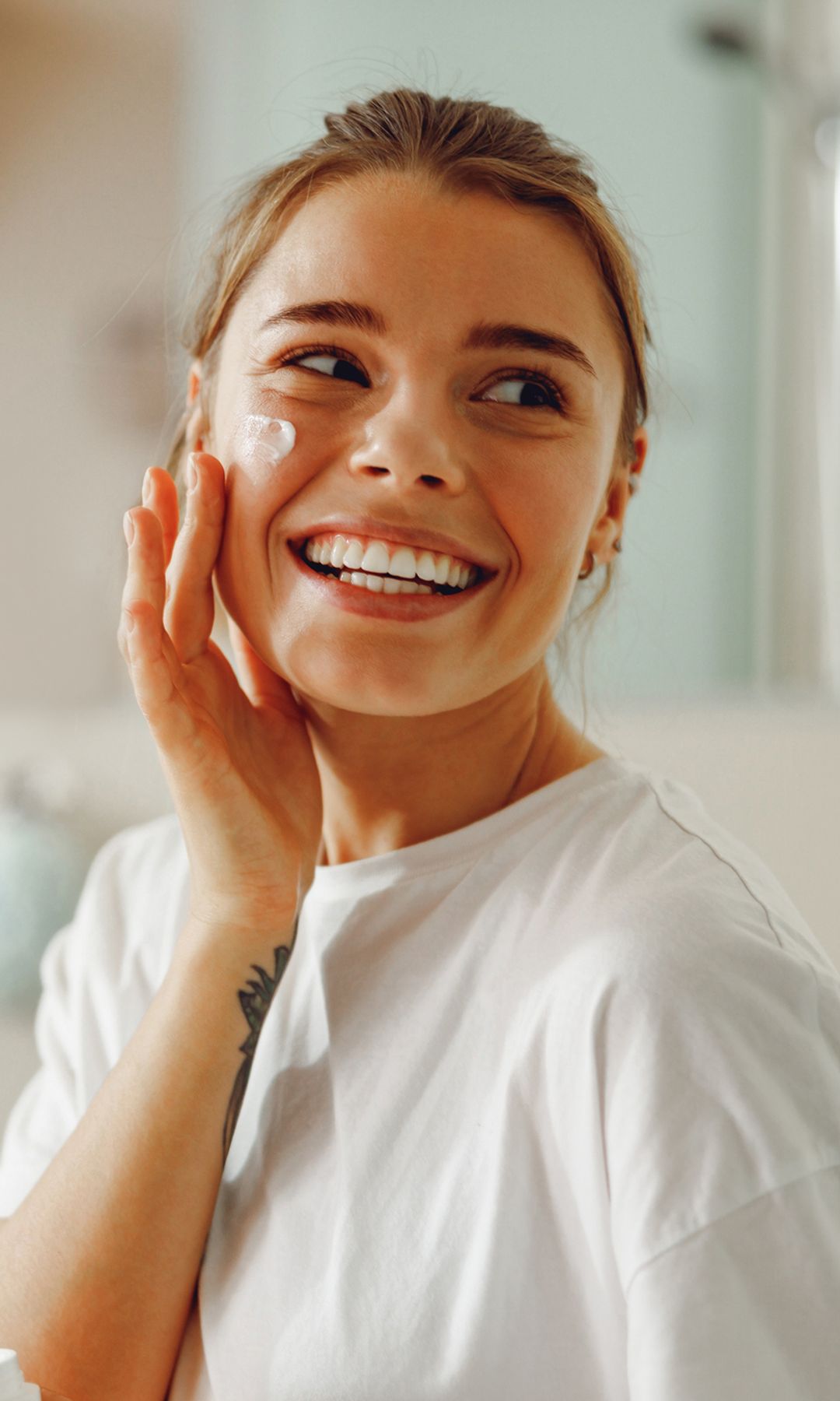 Una mujer poniéndose crema hidratante