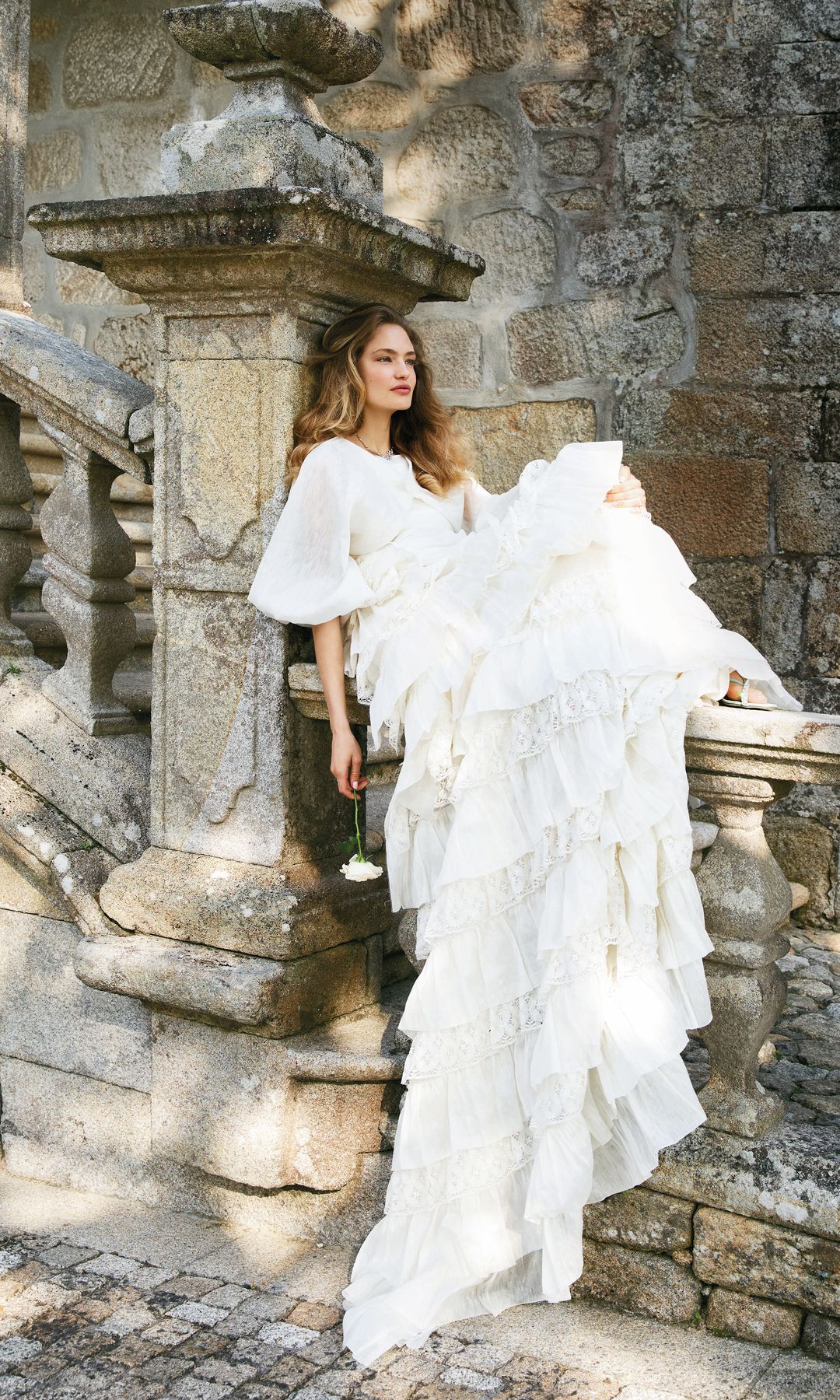 HECHIZO NÍVEO
La delicadeza de ciertos tejidos marca la diferencia de un look nupcial capaz de enamorarnos desde el primer instante. Un claro ejemplo es este vestido de satén con abrigo de volantes, de Lorena Formoso, que luce nuestra flamante novia en estas páginas, acompañado de gargantilla y pendientes de plata bañada en oro con cristales, de Paulet; anillo solitario en oro blanco con montura de diamantes, de Mumit, y sandalias de tacón en satén con aplicaciones, de Jimmy Choo