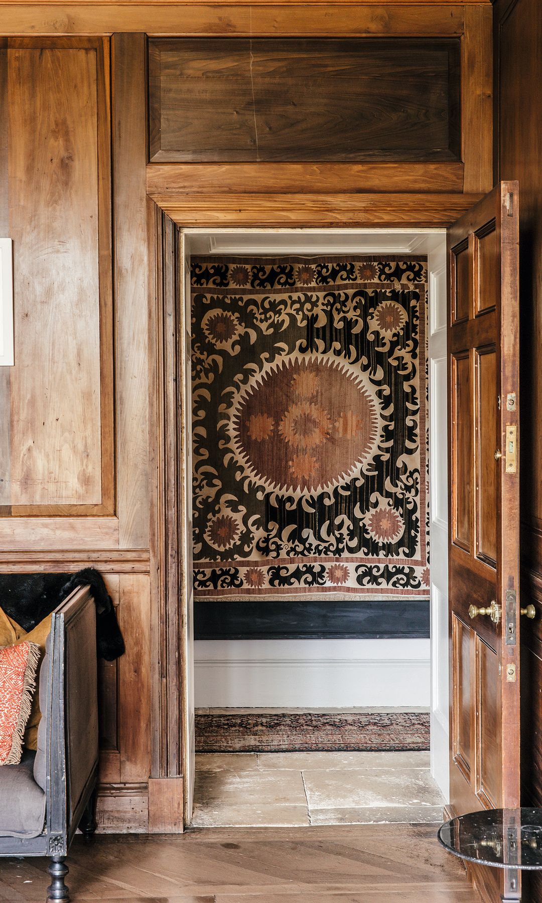 Puerta abierta que muestra un pasillo con alfombra decorativa