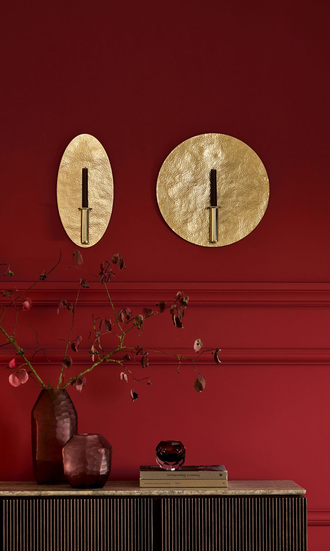 Pared de color rojo oscuro, jarrones de color burdeos, con ramas burdeos, adornos dorados 