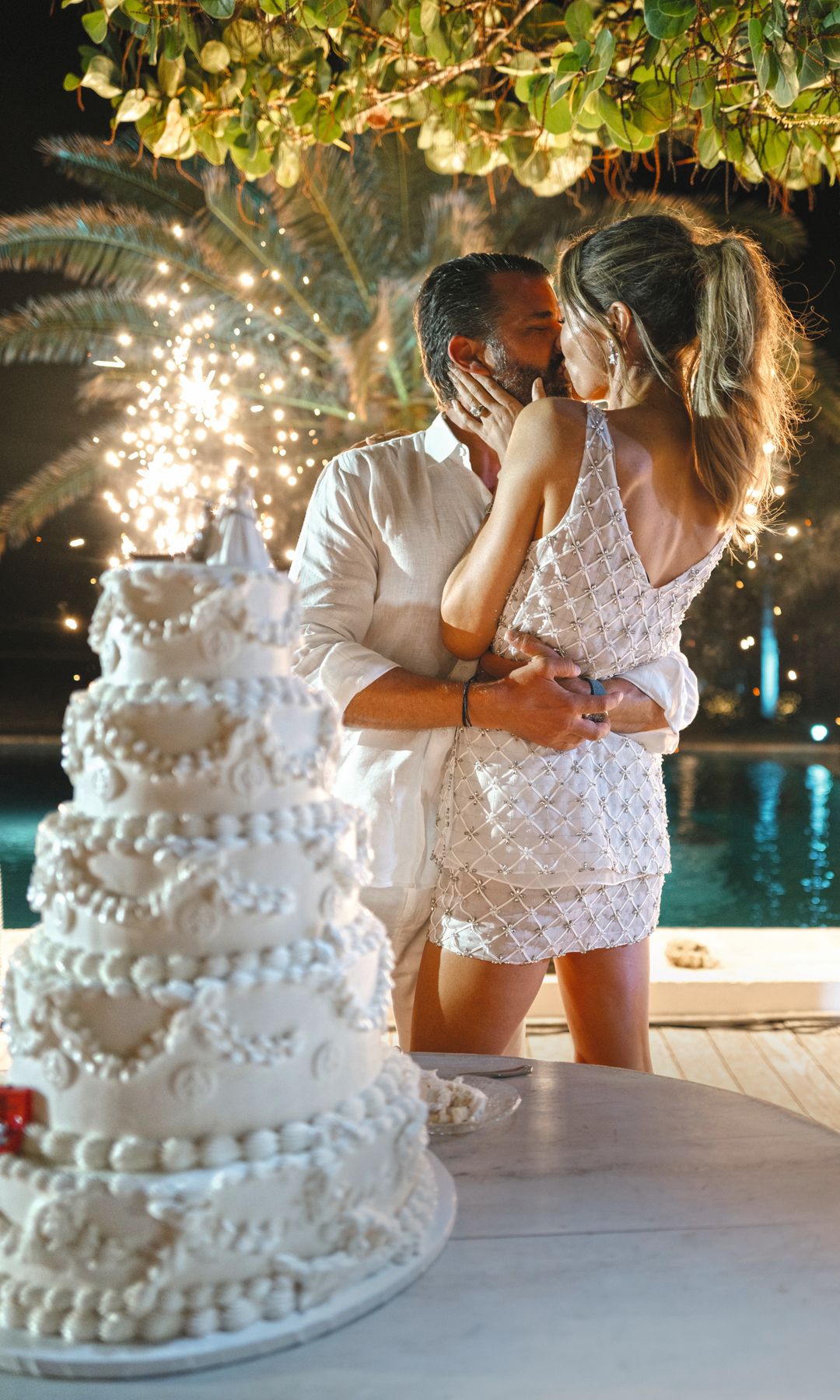 La pareja junto a la tarta nupcial. La novia lució un segundo "look" de dos piezas, de Safiyaa