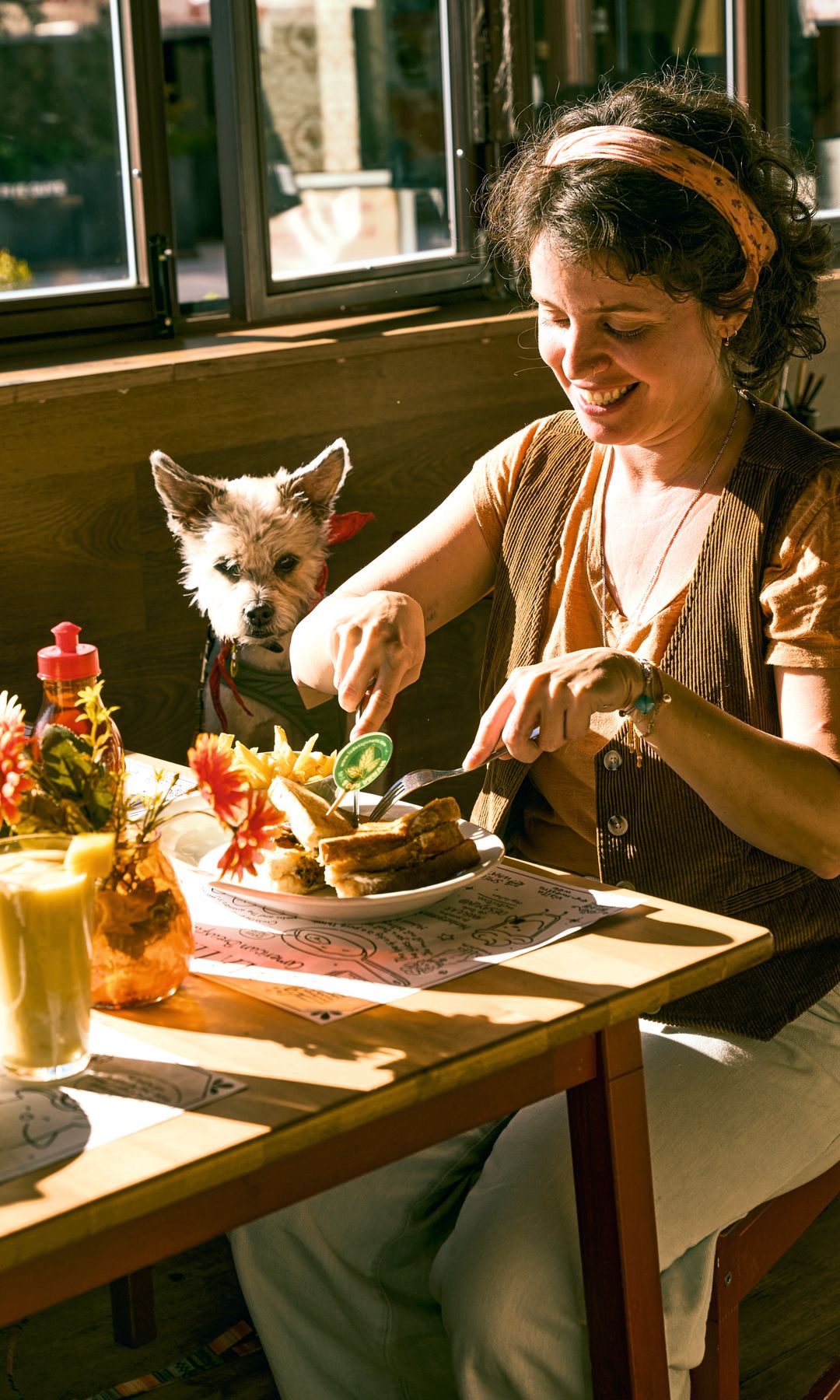 Mujer desayunando con su perro en el local de La Desayunería en Madrid.